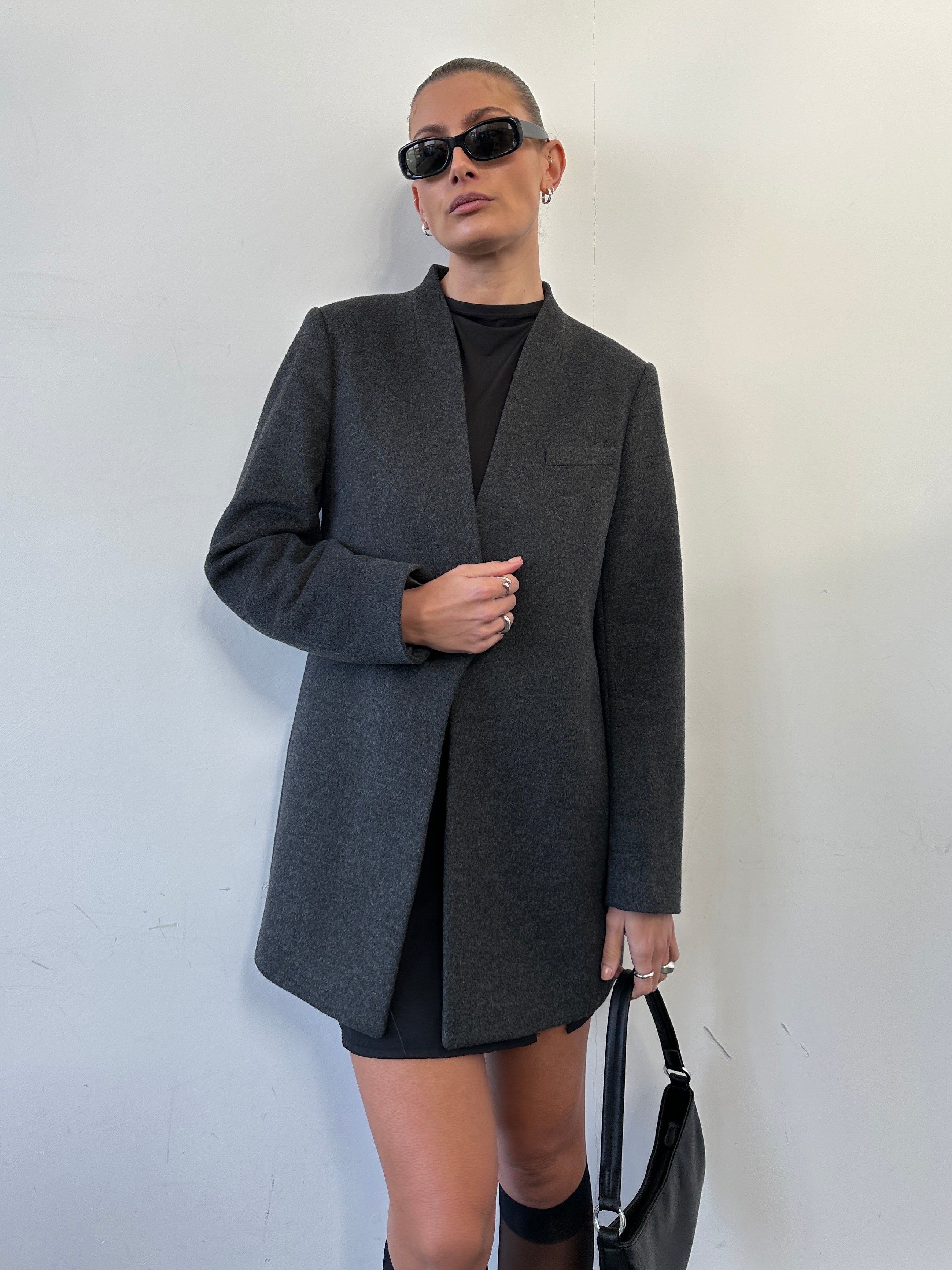 Jaeger minimal wool cashmere coat in size M, shown on a hanger with a tailored silhouette and soft beige fabric.