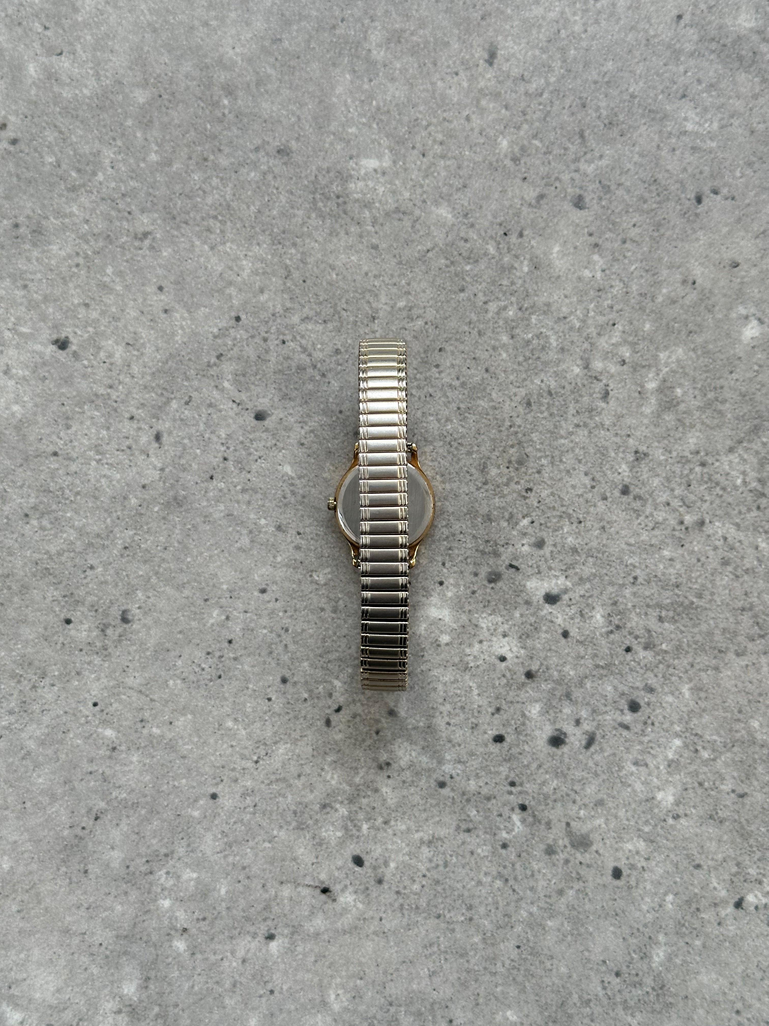 Accurist 1990s gold-tone quartz watch with a round face and classic design, featuring a metal bracelet and analog display.