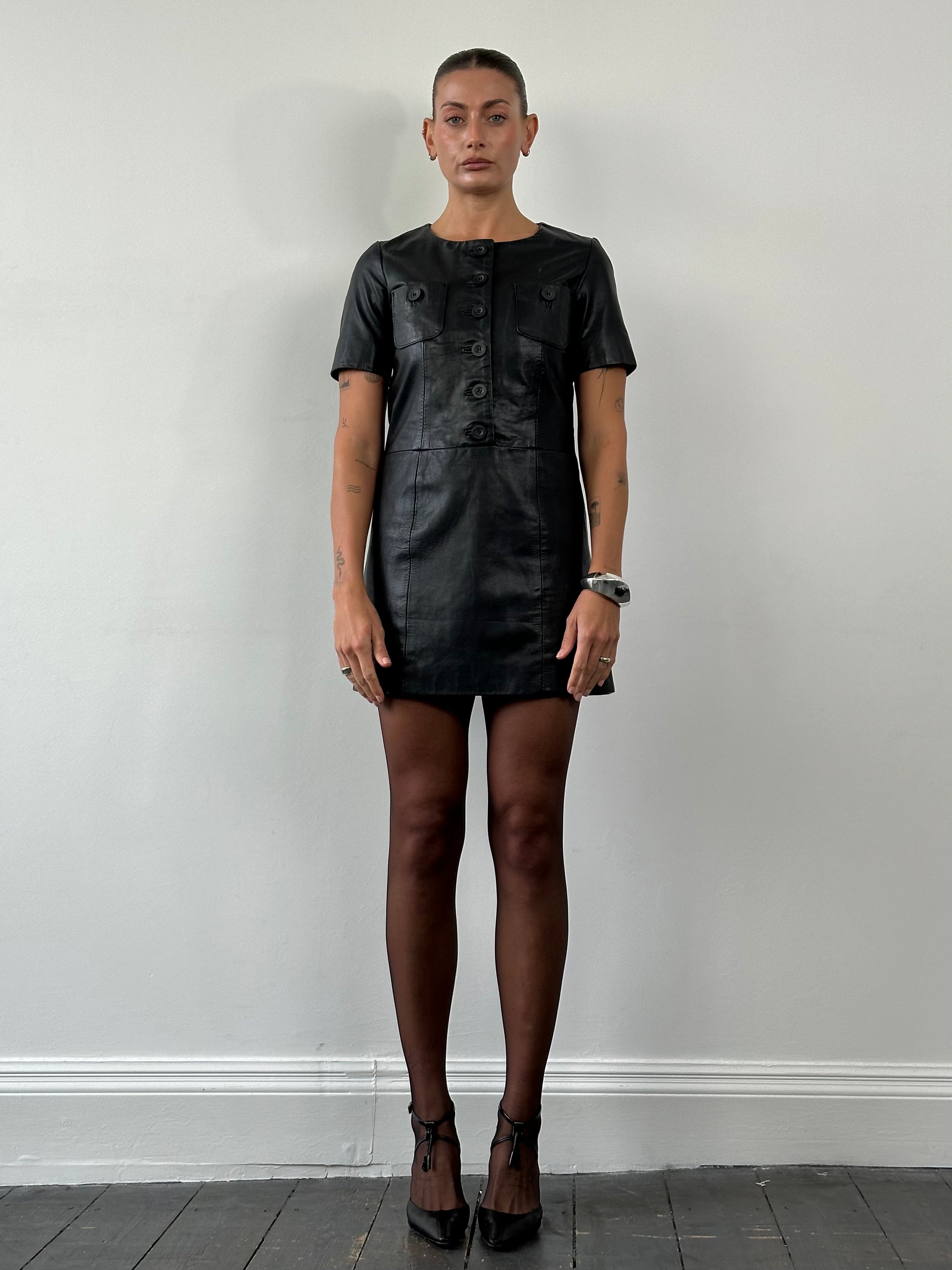 Vintage leather mini dress in size small, featuring a sleek, fitted design with a classic collar and short sleeves.