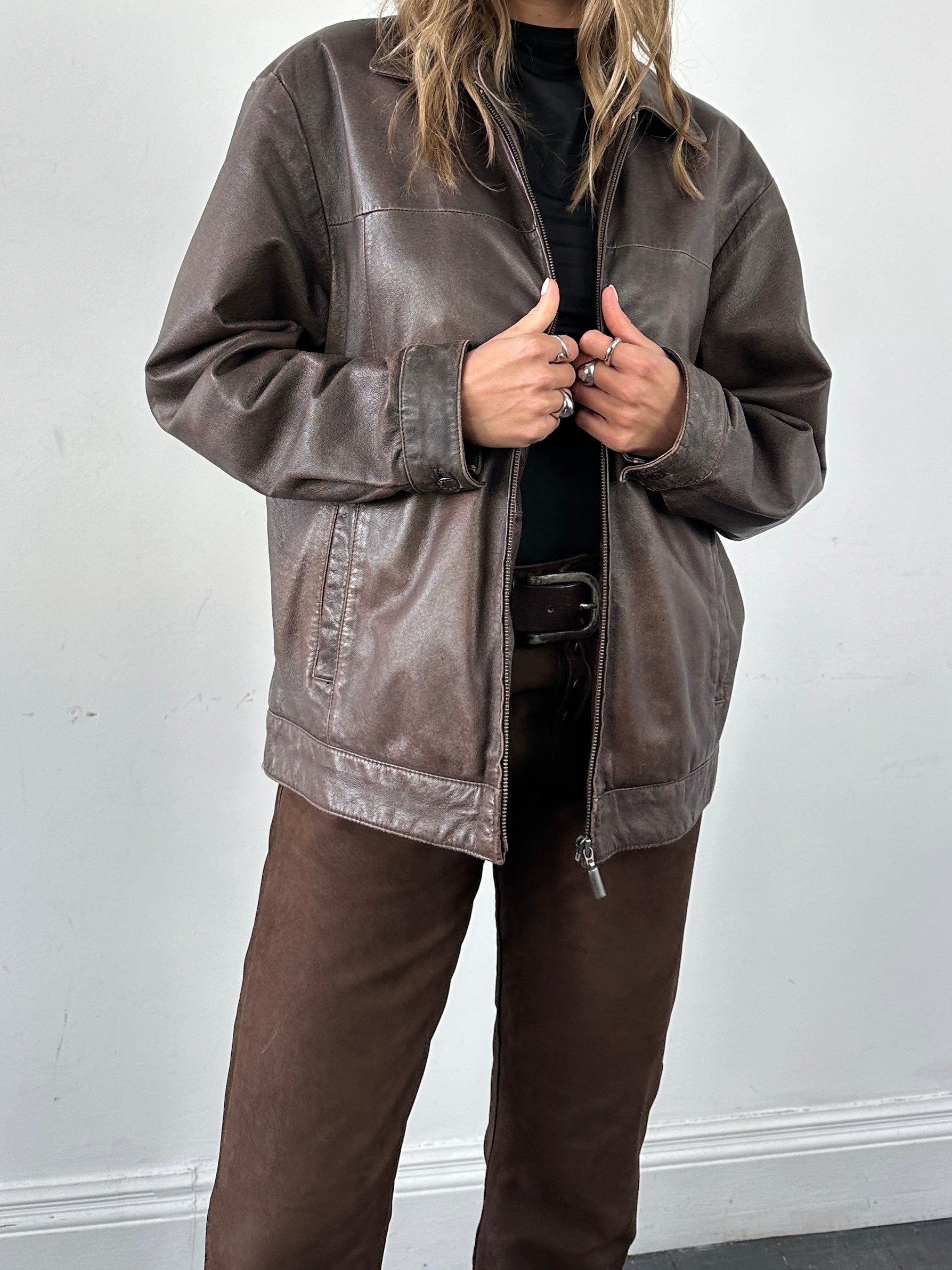 Vintage distressed leather jacket in size M/L, featuring a classic rugged design with worn-in details and metal hardware.