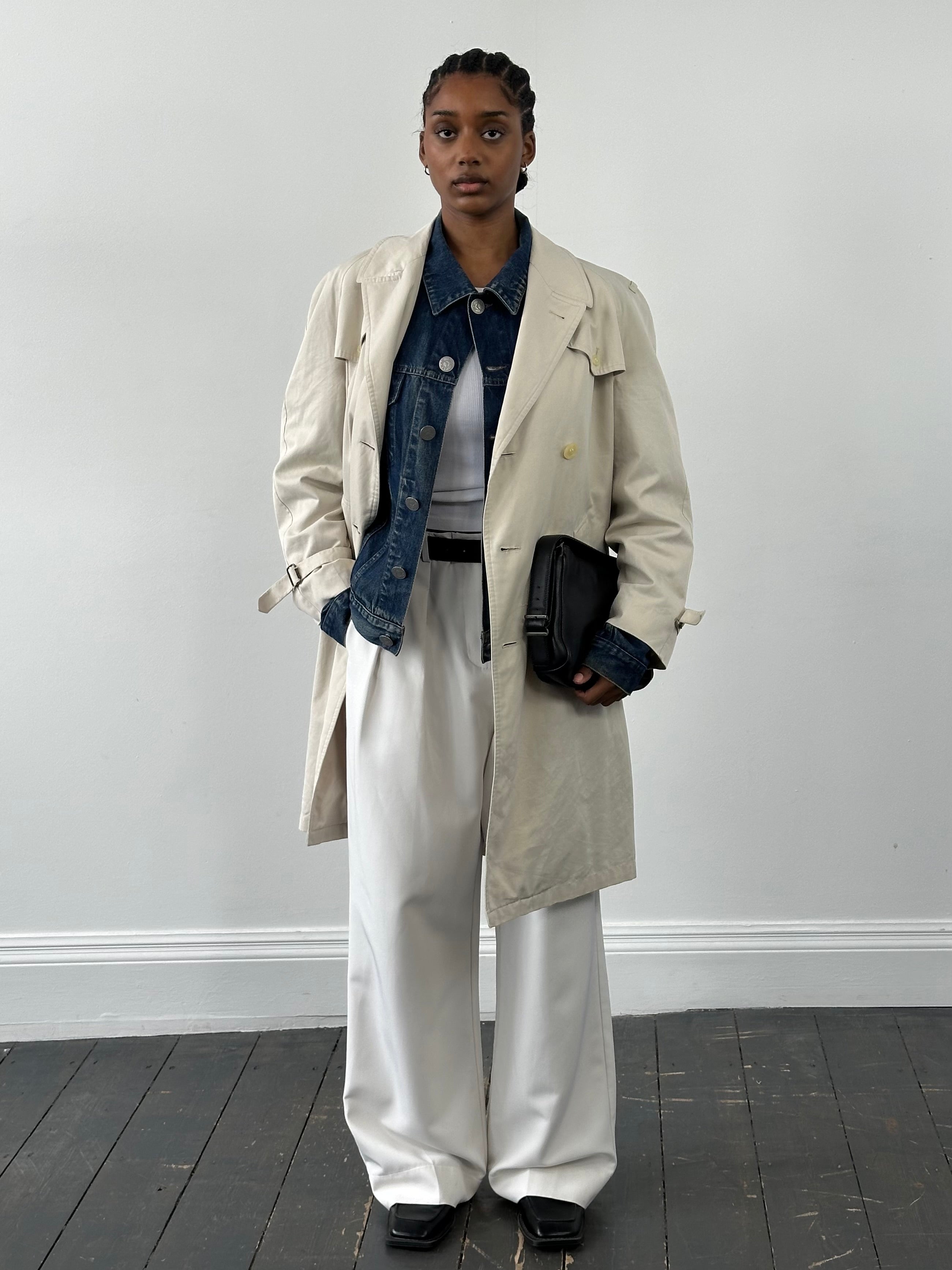 Burberry 1990s cotton double-breasted trench coat in beige, featuring classic collar and waist belt, displayed on a hanger.