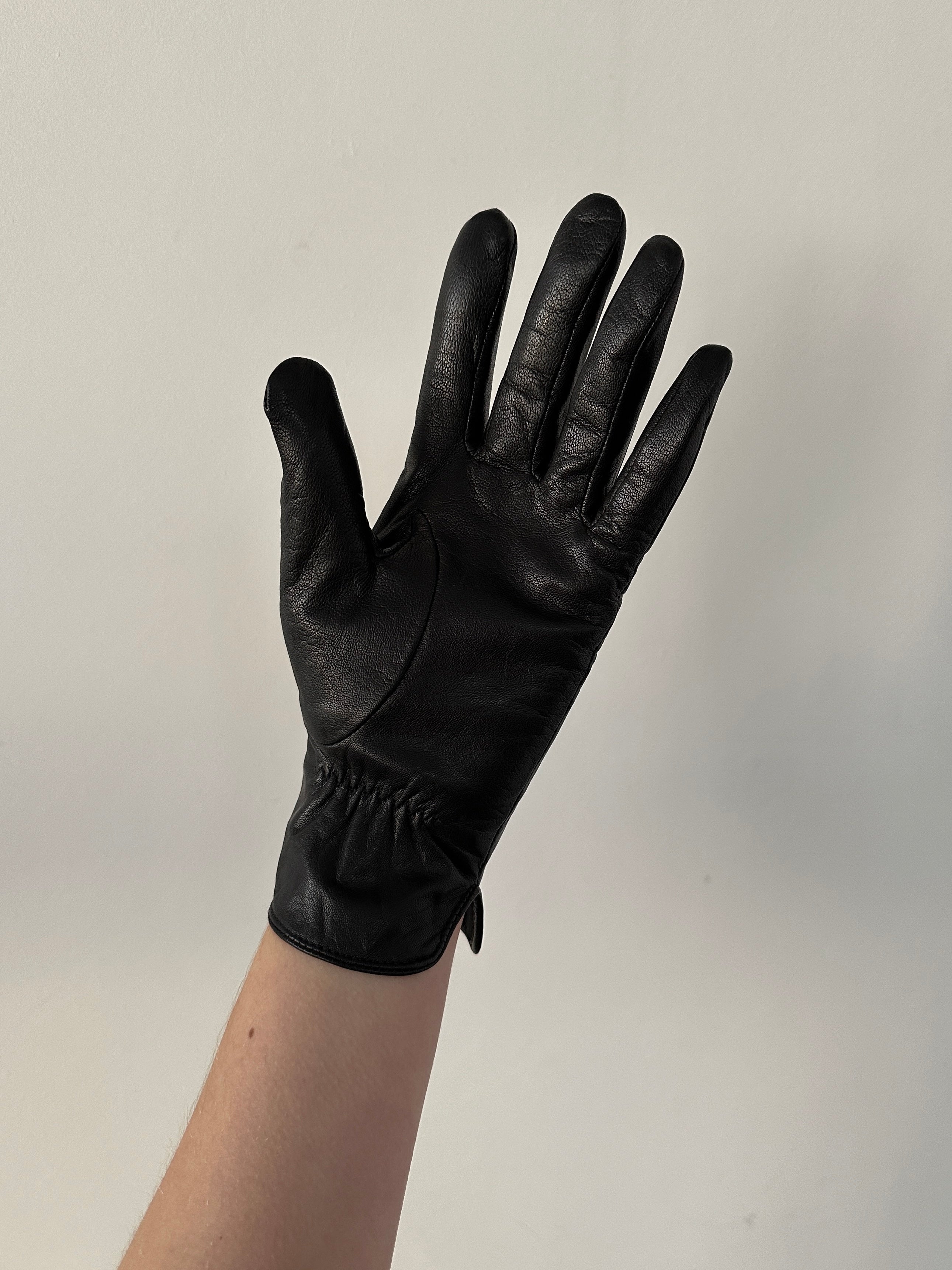 Vintage leather gloves with detailed stitching, classic design, and soft texture shown in the image.