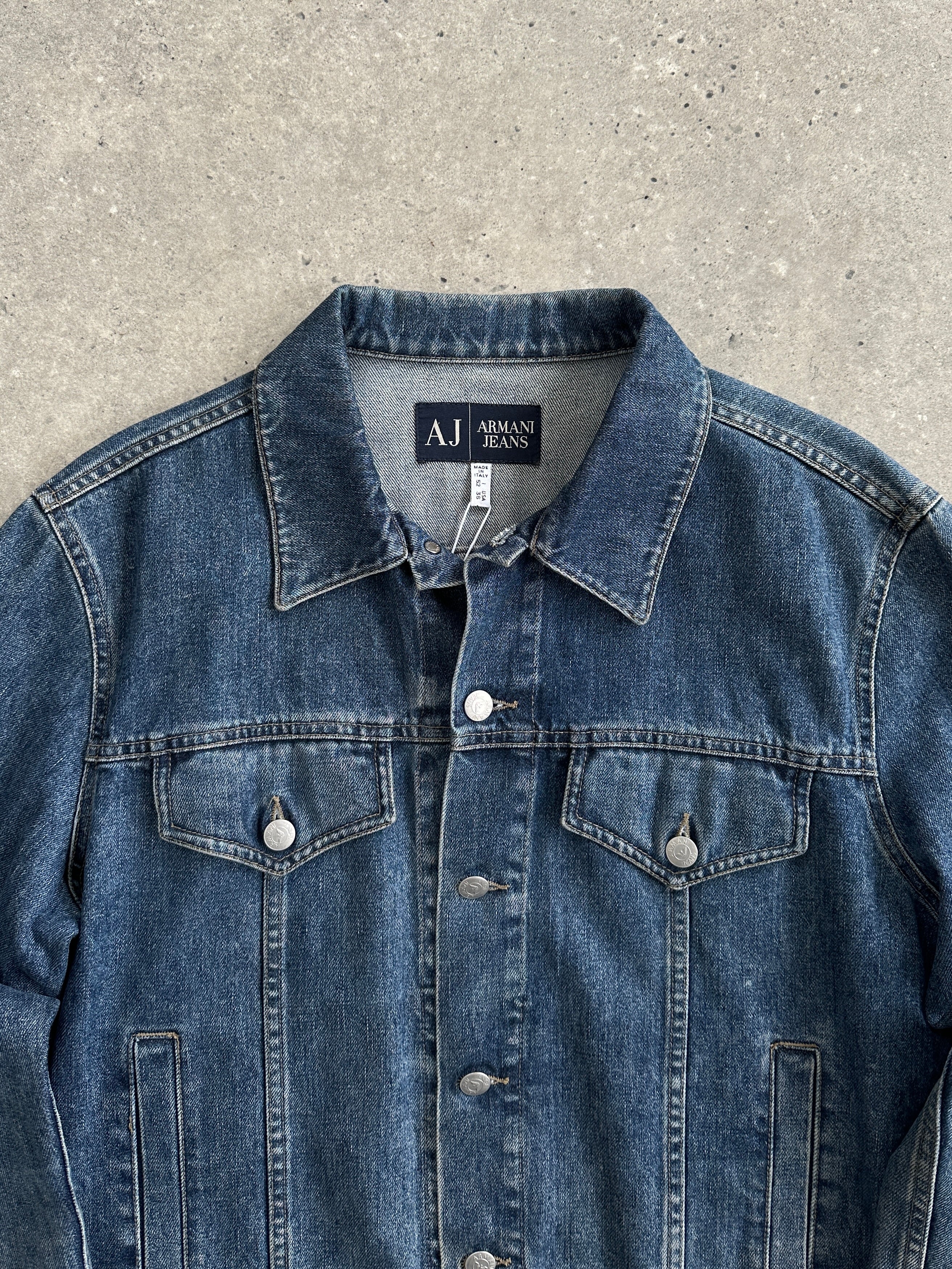 Armani Jeans denim jacket, men's size M, showcasing classic blue denim with button-front closure and stylish collar.