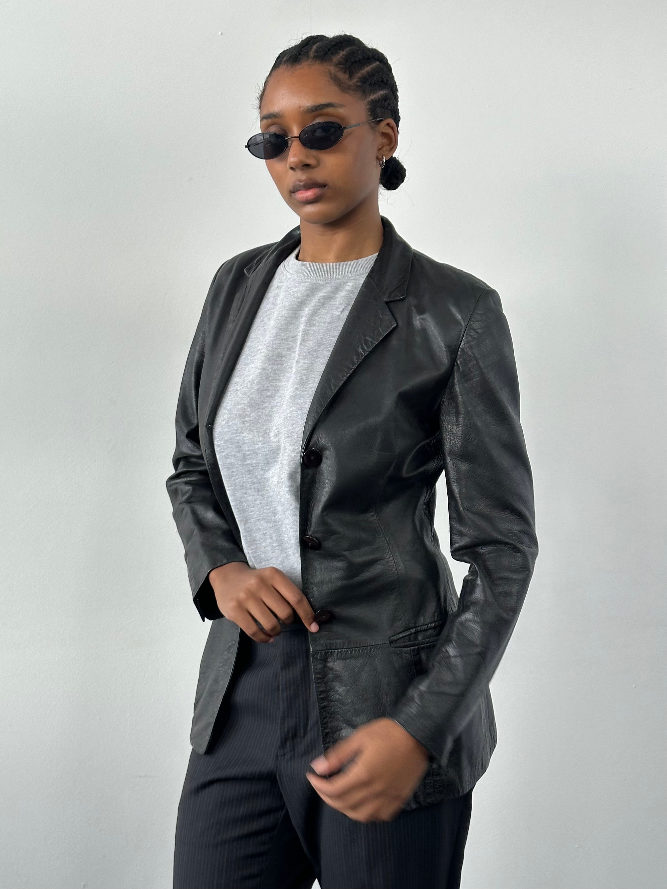 Versace 1990s fitted leather jacket in XS with classic design and detailed stitching, displayed on a hanger.