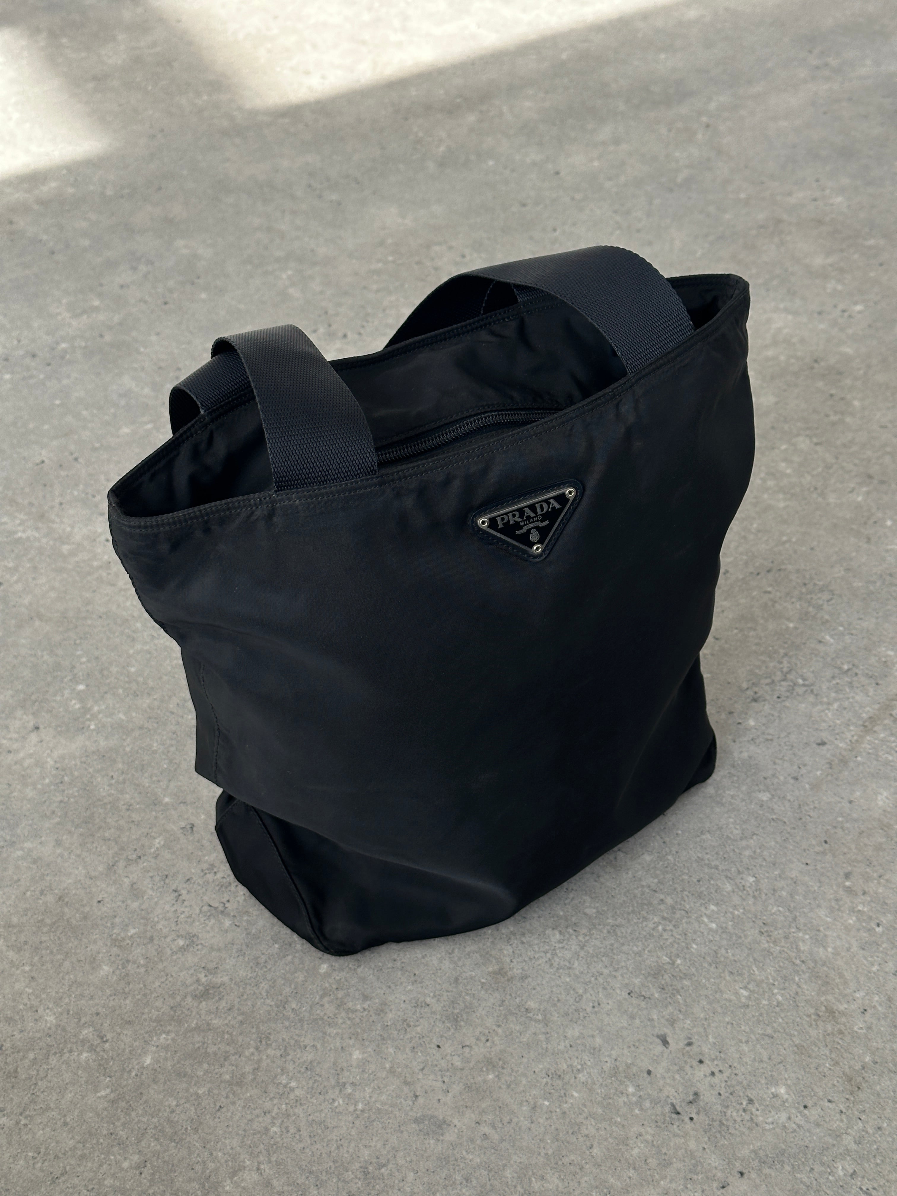 Prada 1997 nylon shoulder bag with adjustable strap and minimalist design, featuring the Prada logo on the front.
