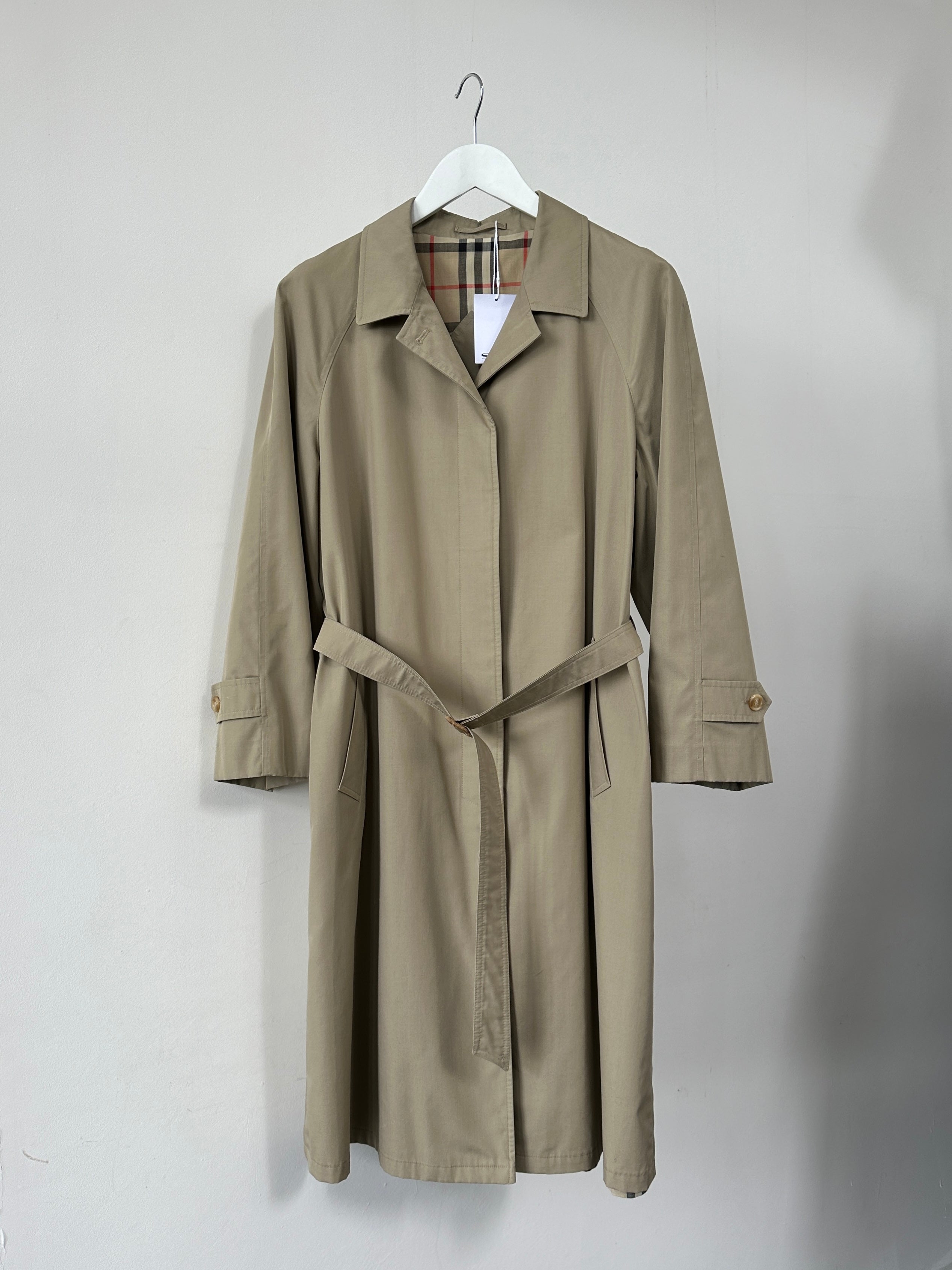 Vintage showerproof belted trench coat in size M, stylish outerwear with classic design, perfect for rainy weather.