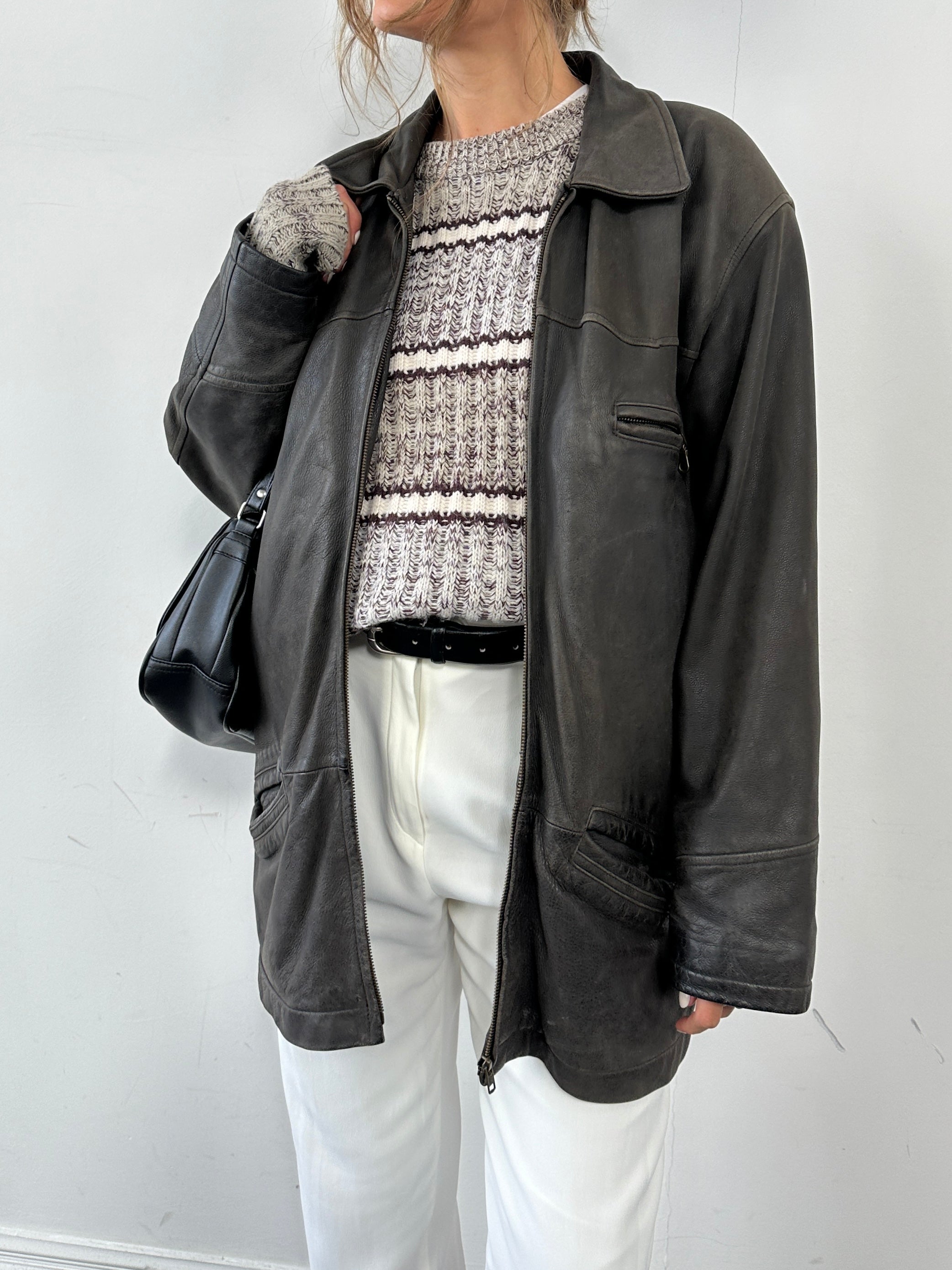 Vintage mid-length leather jacket in size L/XL, featuring classic design and smooth brown leather, displayed on a hanger.