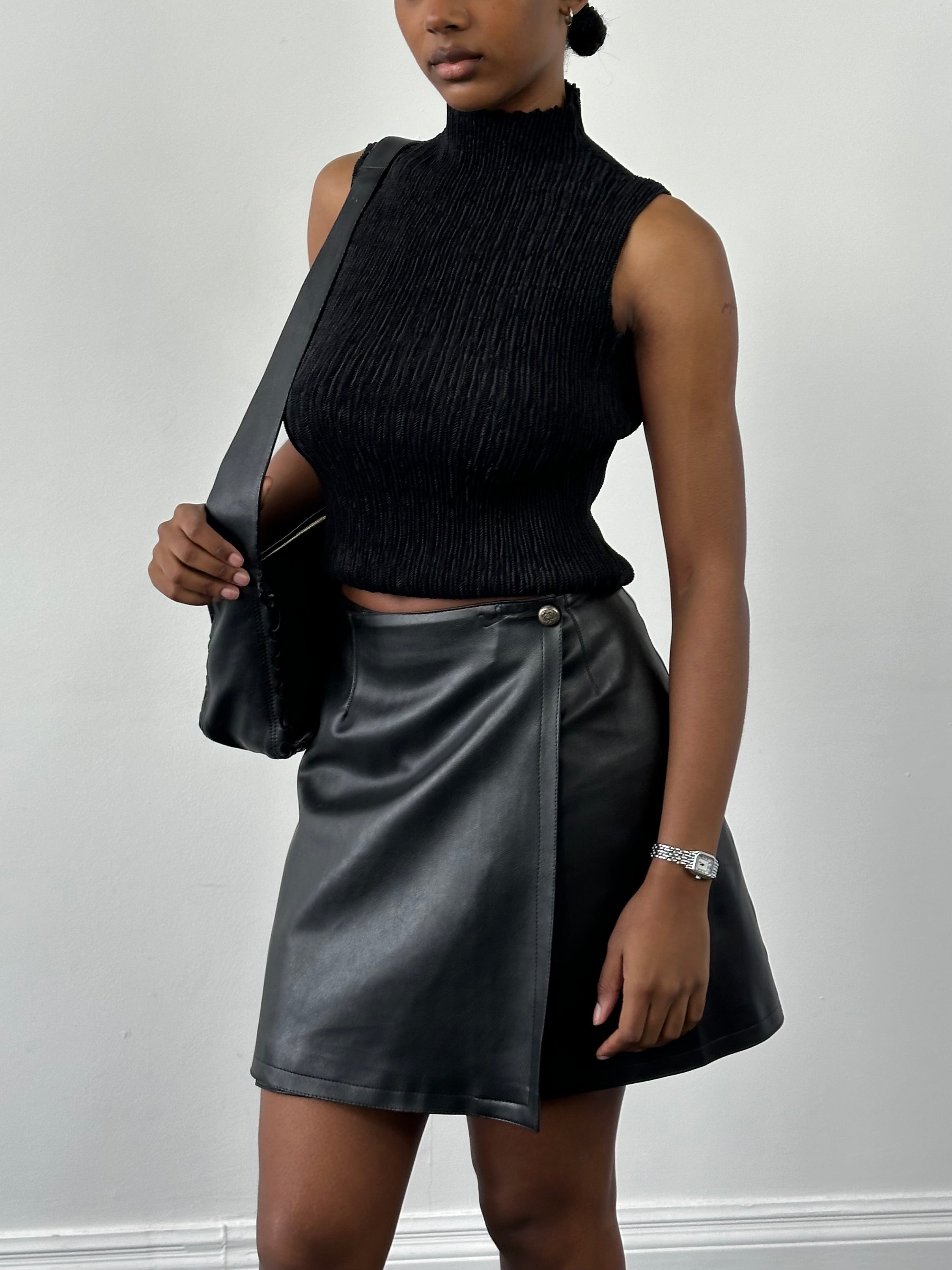 Vintage faux leather wrap mini skirt with high waist and sleek design, perfect for stylish casual or night-out looks.