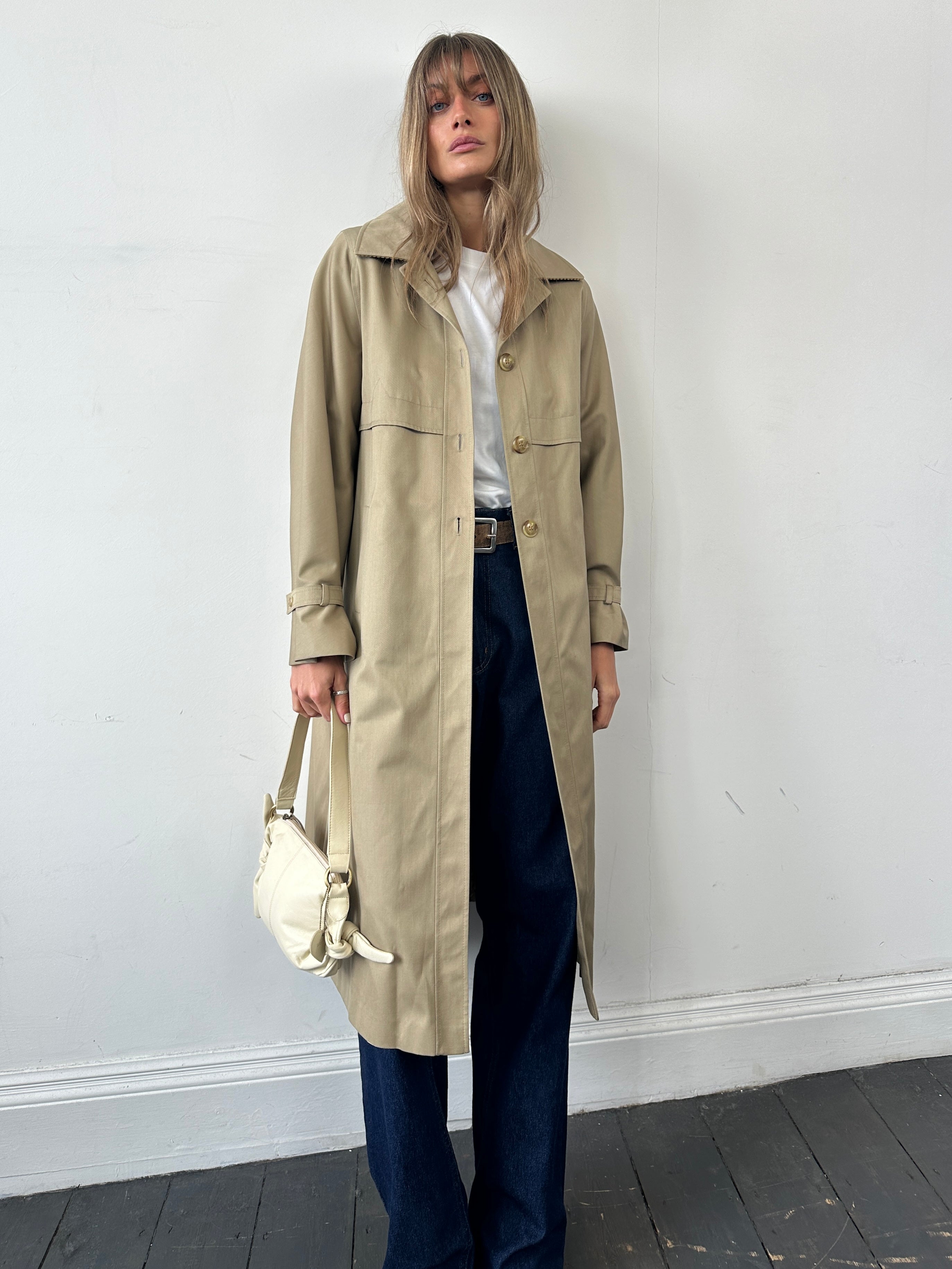 Vintage single-breasted trench coat in size S, classic style with belt and lapel, displayed on a hanger.