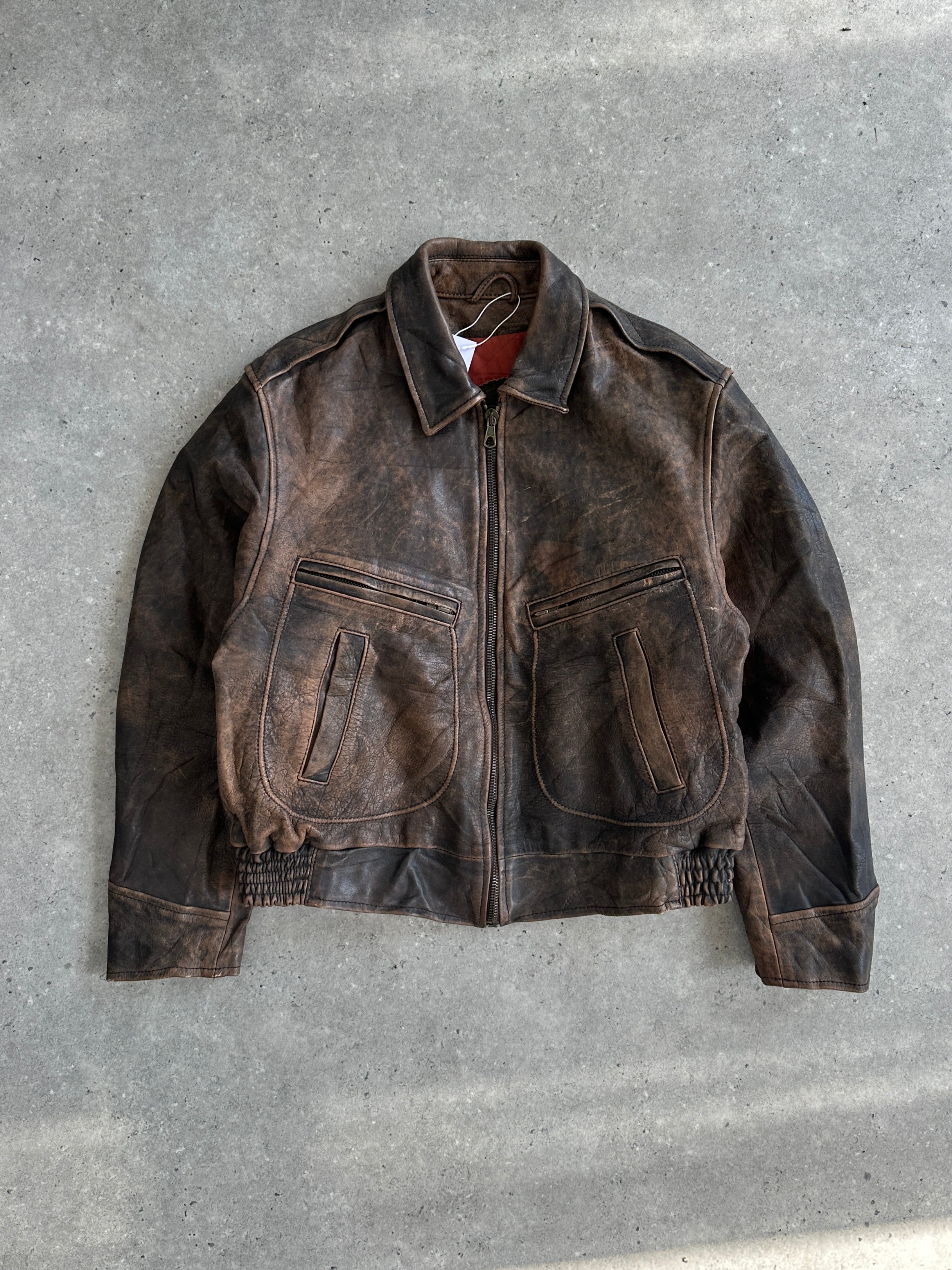 Vintage distressed leather bomber jacket in size M/L, featuring rugged texture and classic design, shown on a hanger.