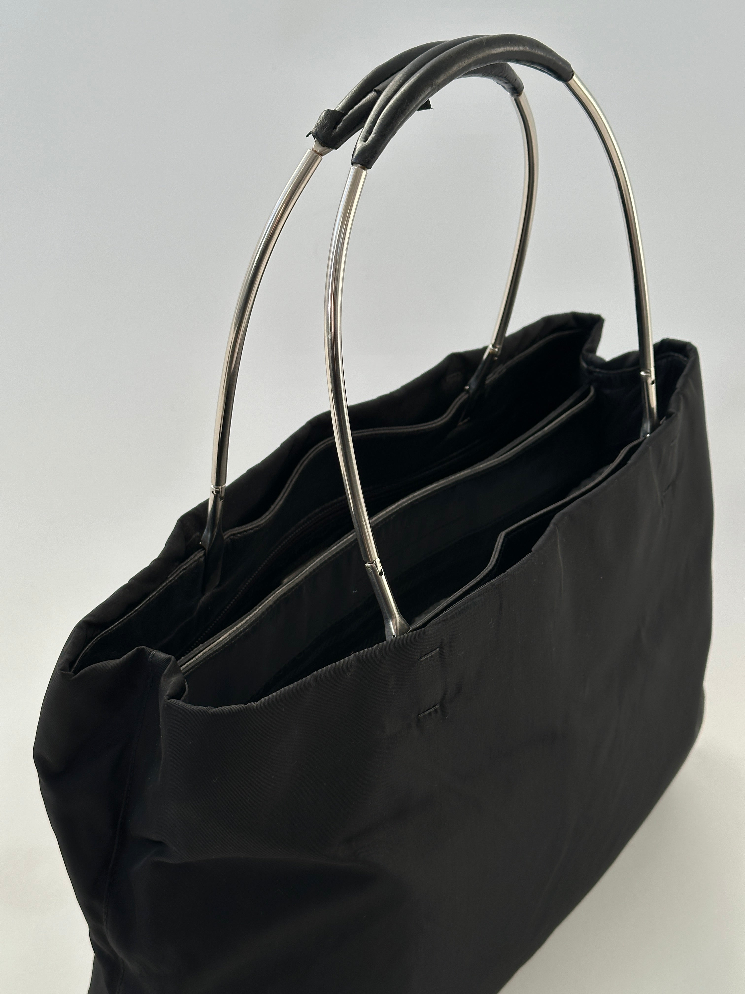 Prada nylon and leather tote bag with sleek design, sturdy handles, and spacious interior for everyday use.