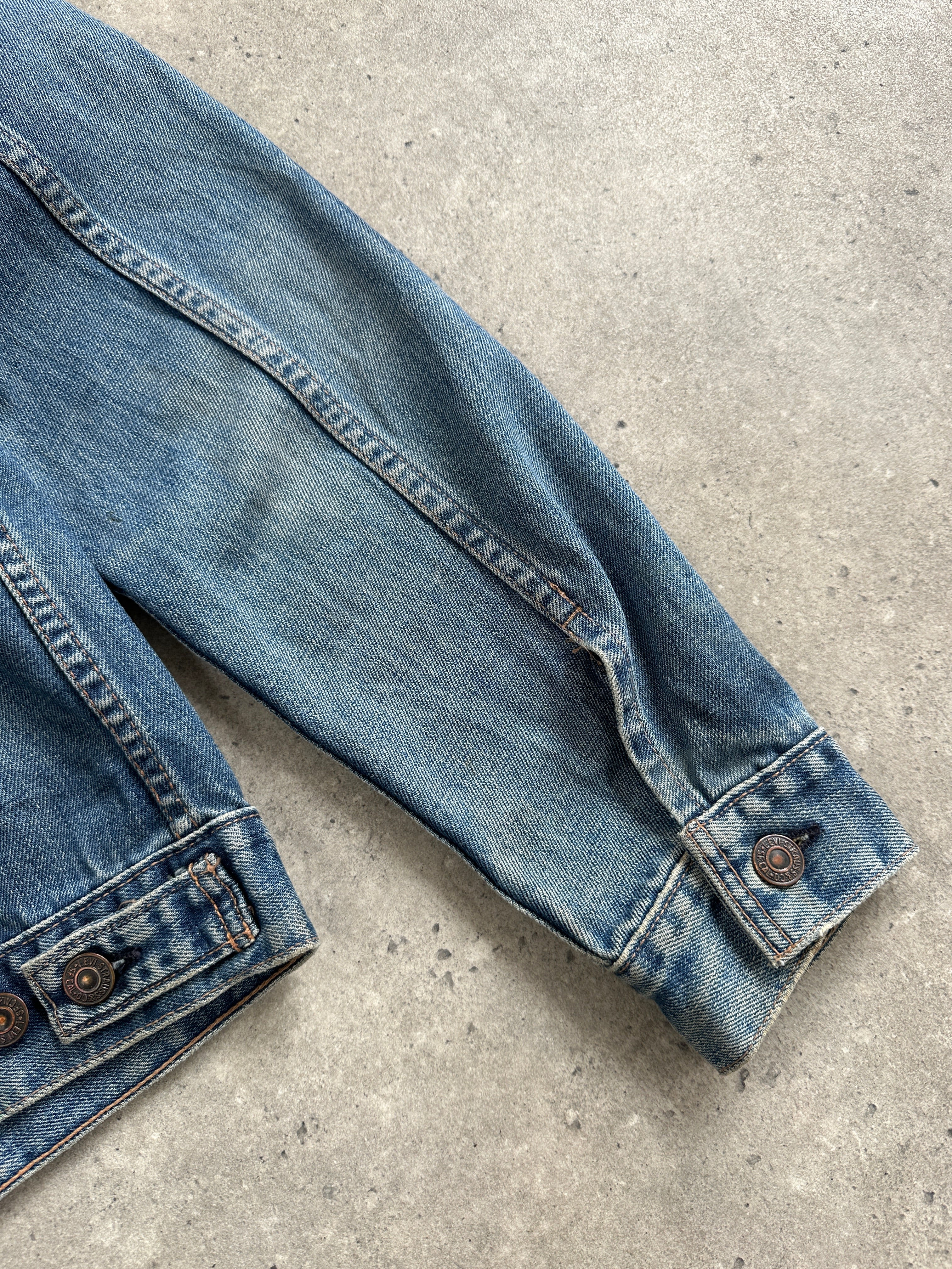 Levi’s 1990s faded denim jacket in medium size, featuring classic distressed denim and vintage style.