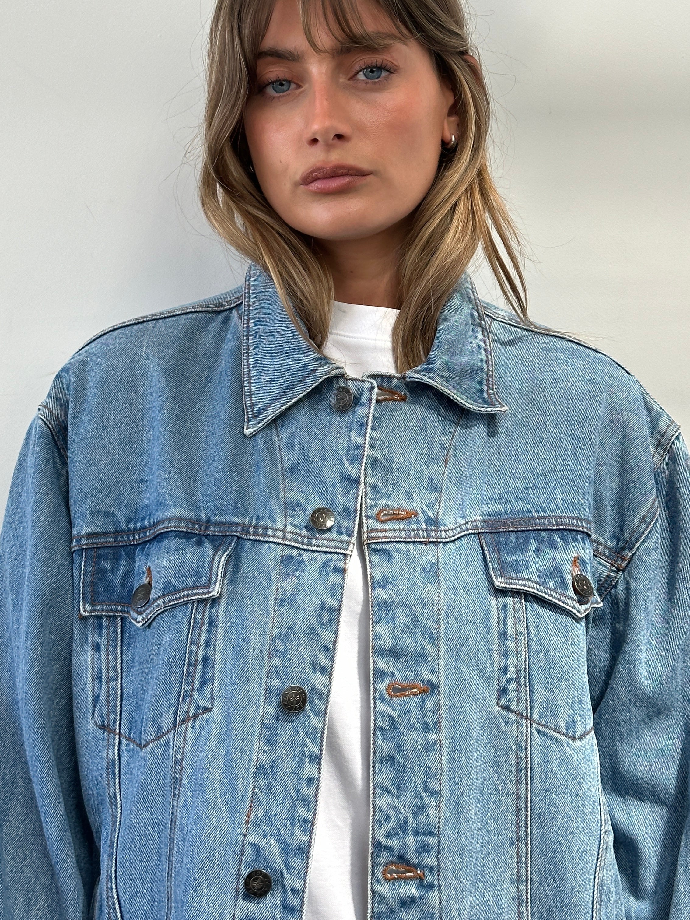 Vintage oversized pure cotton denim jacket, M/L, featuring classic design and durable fabric, displayed on a hanger.