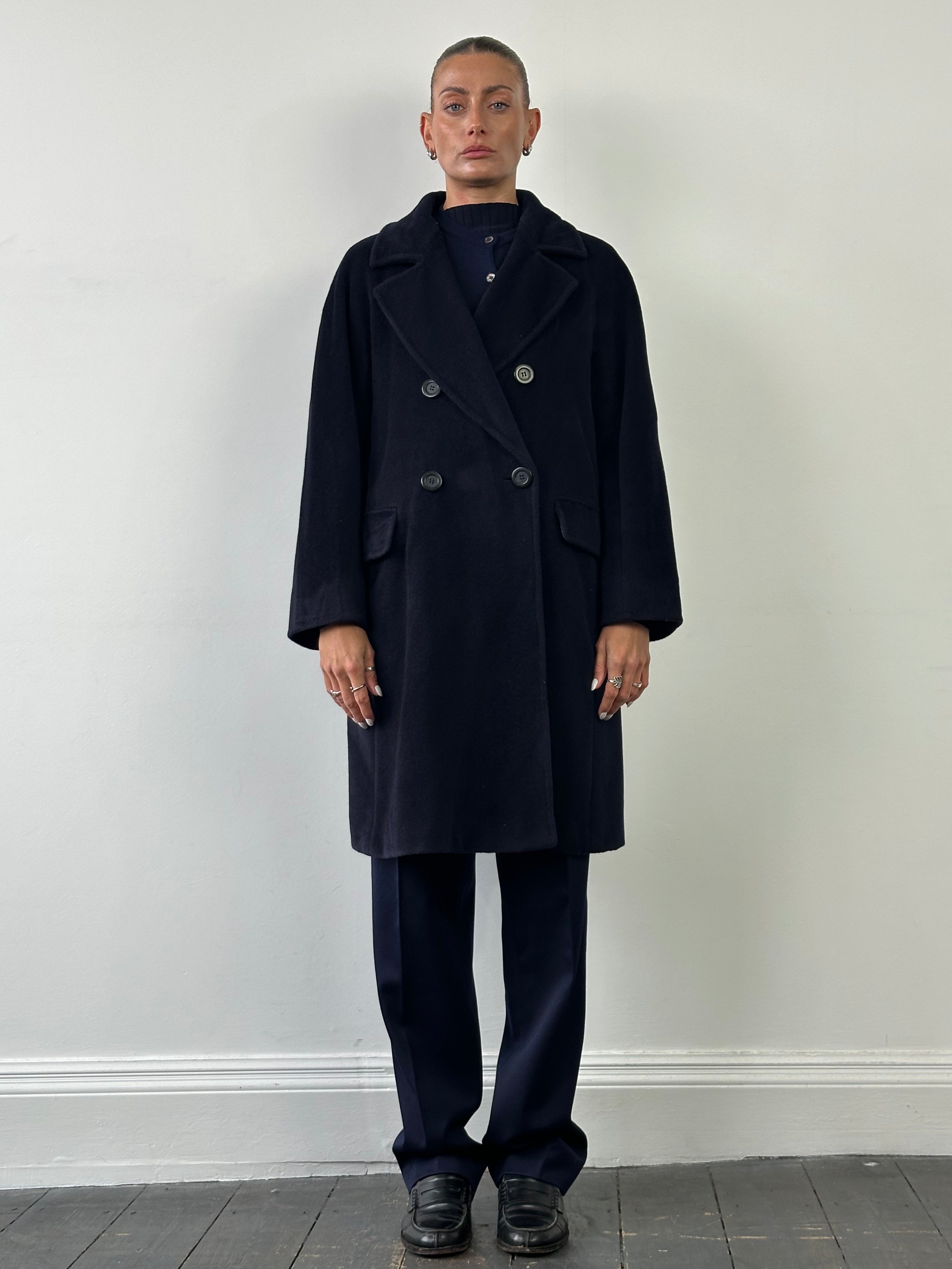 Max Mara wool cashmere double-breasted A-line coat in size L, shown hanging on a hanger with a classic lapel design.