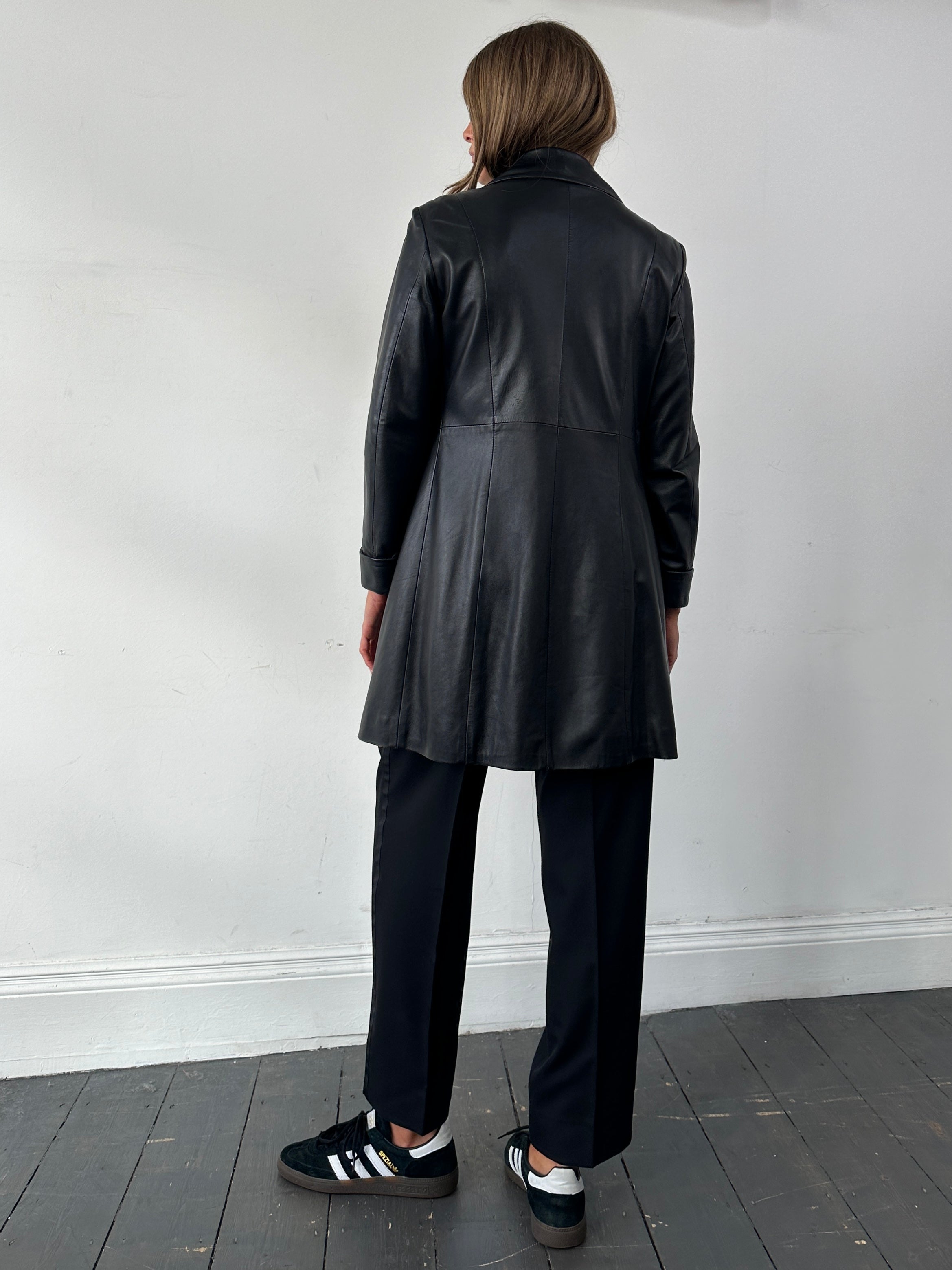 Vintage Italian vintage mid-length leather jacket with classic design, displayed on a hanger.