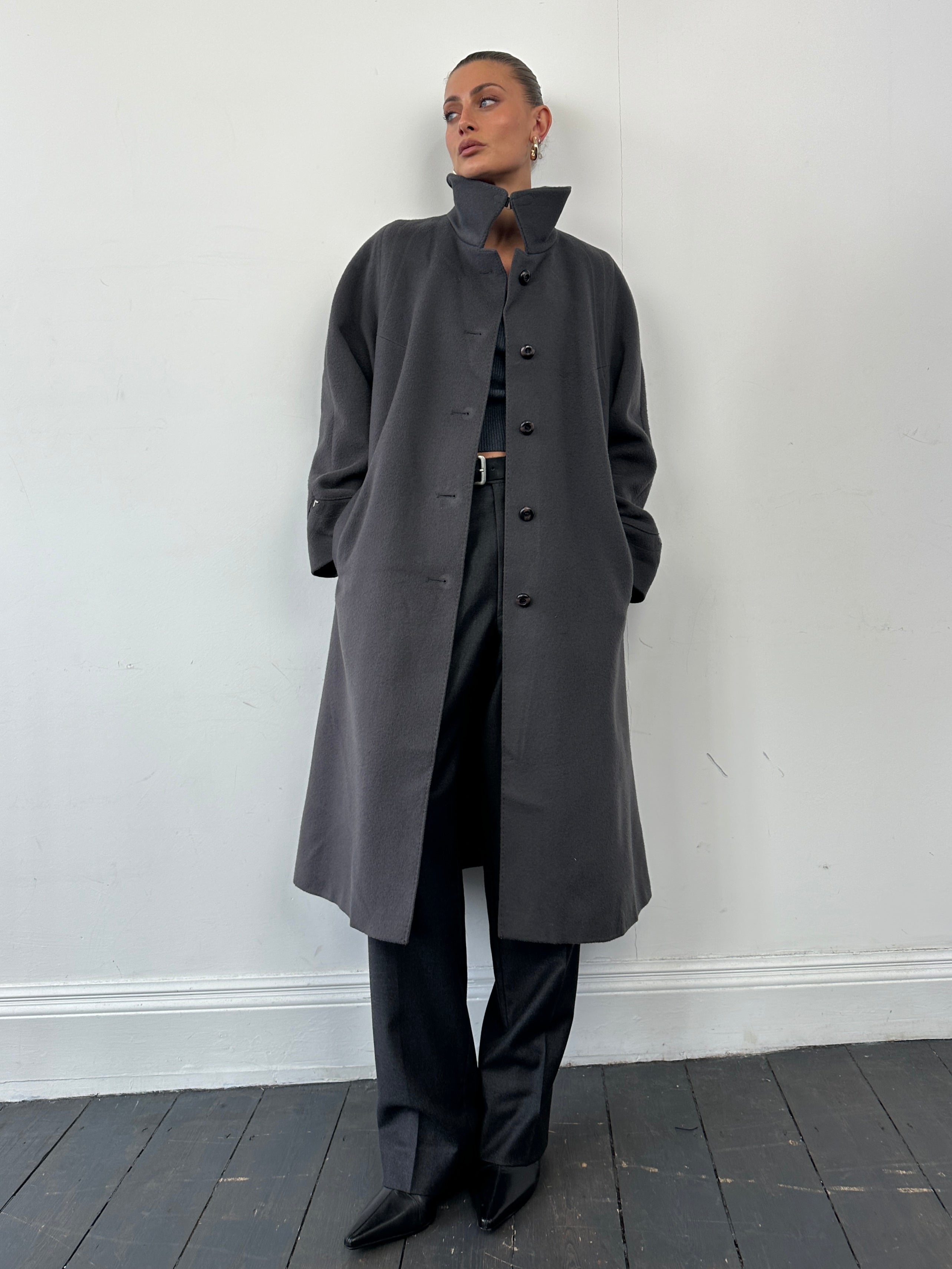 Vintage brand wool single-breasted coat in size M, showing classic tailored design and textured fabric in a natural pose.