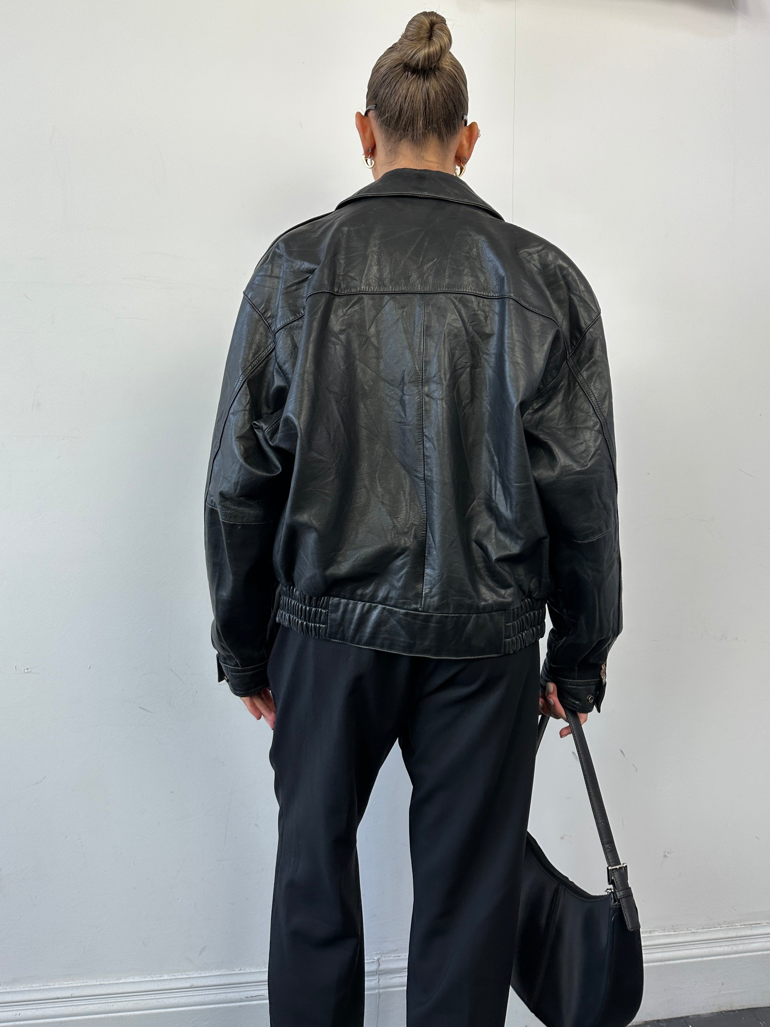 Vintage leather bomber jacket in size S/M, stylish vintage leather jacket with classic design and detailed stitching.
