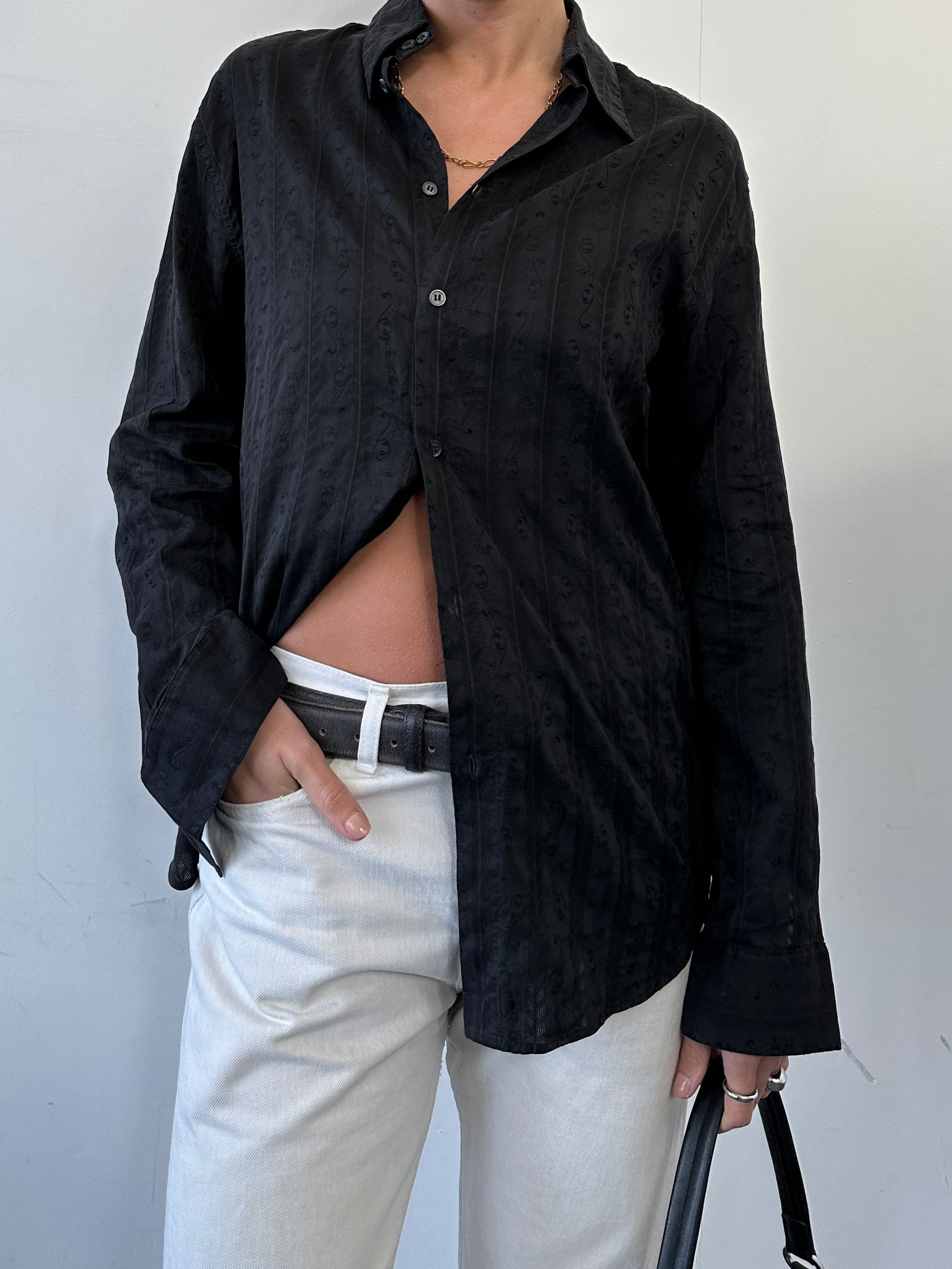 Versace printed shirt in size M featuring bold designer patterns, showcased on a hanger against a neutral background.