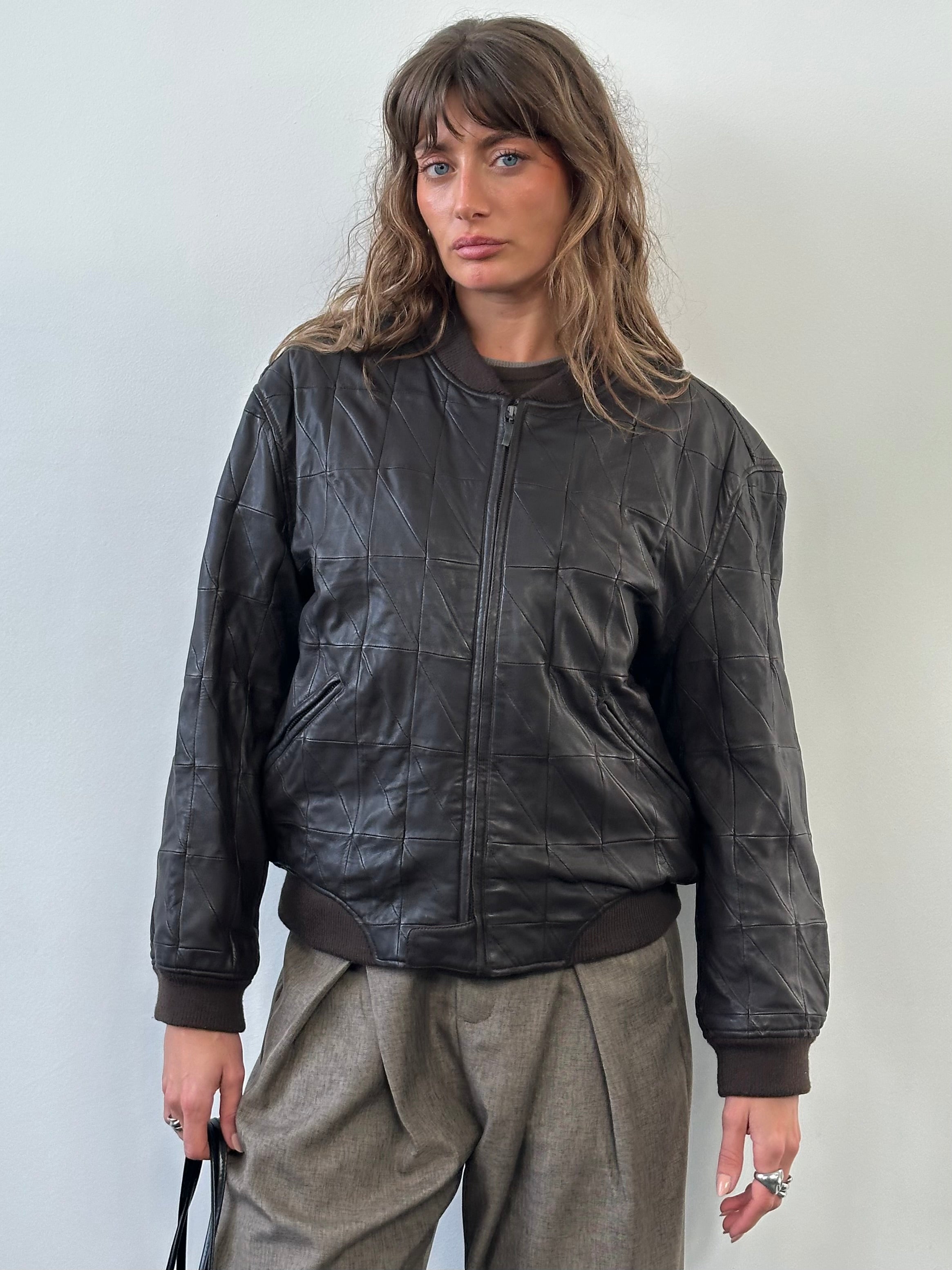 Armani Collezioni 2000s leather bomber jacket in black, featuring classic design, ribbed cuffs, and front zipper, size S/M.