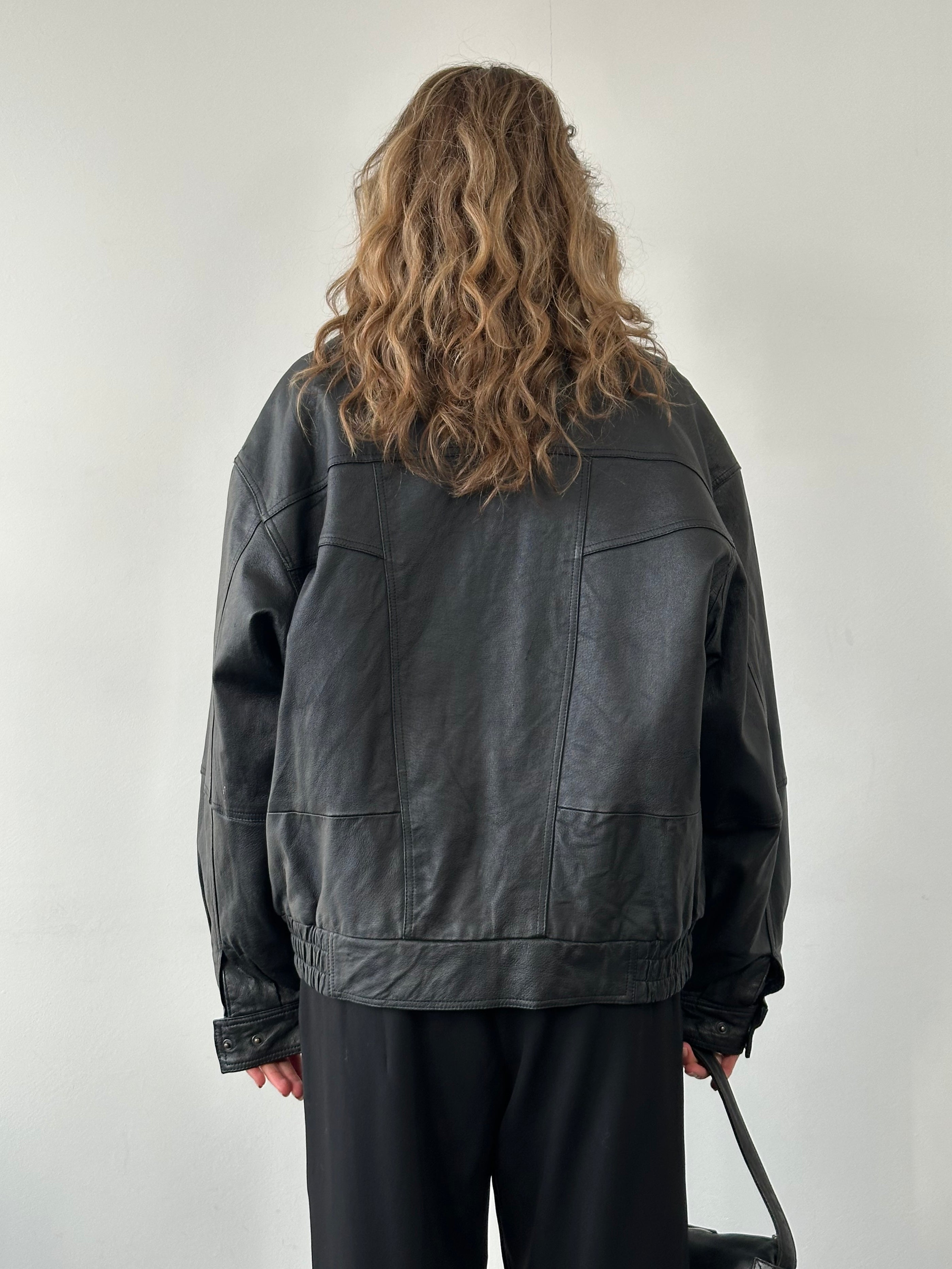 Vintage leather bomber jacket in size L, featuring classic design, ribbed cuffs, and collar, made from high-quality leather.