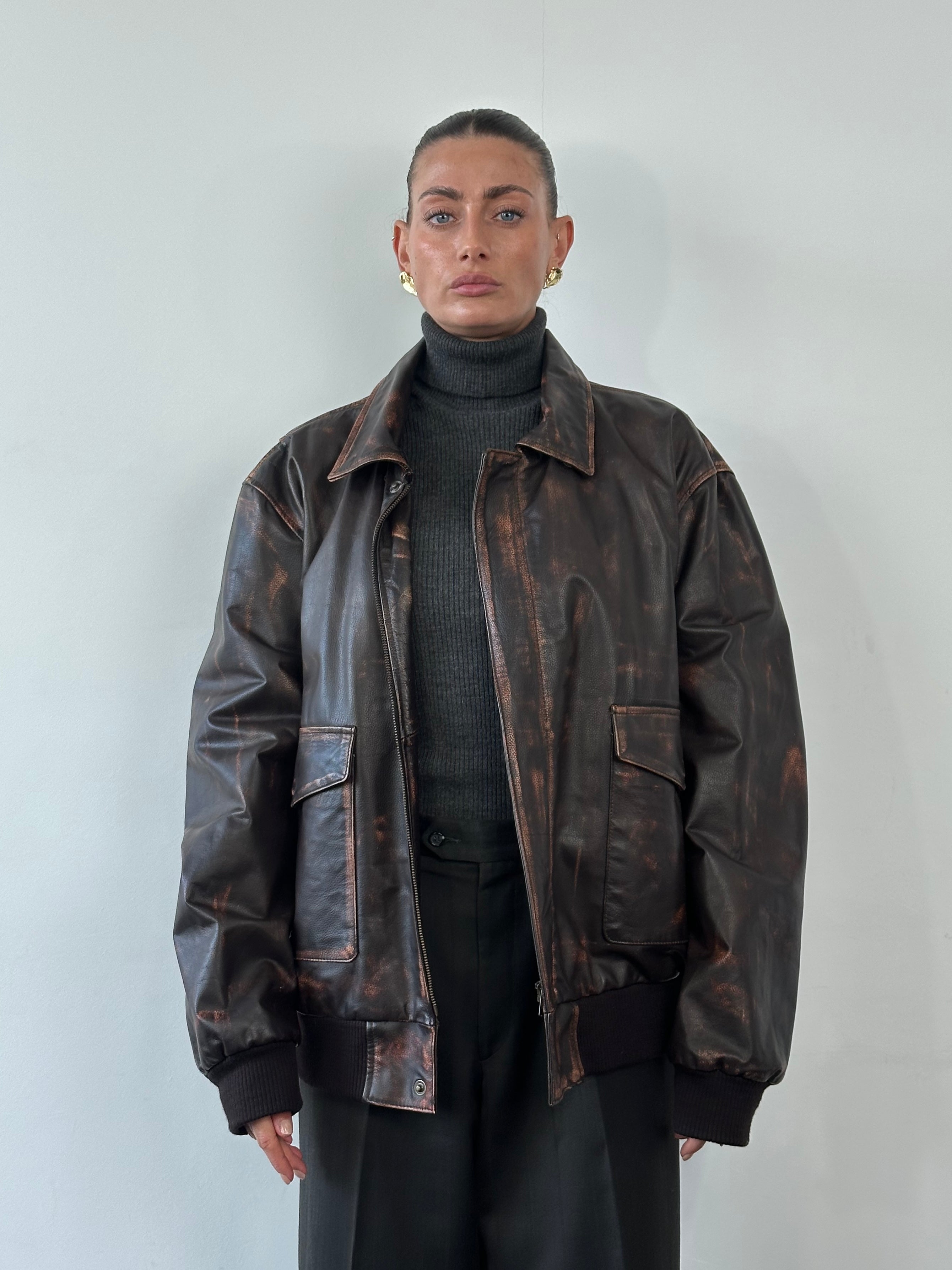 Vintage distressed leather jacket in XL size, featuring a rugged design with worn finish and classic collar detail.