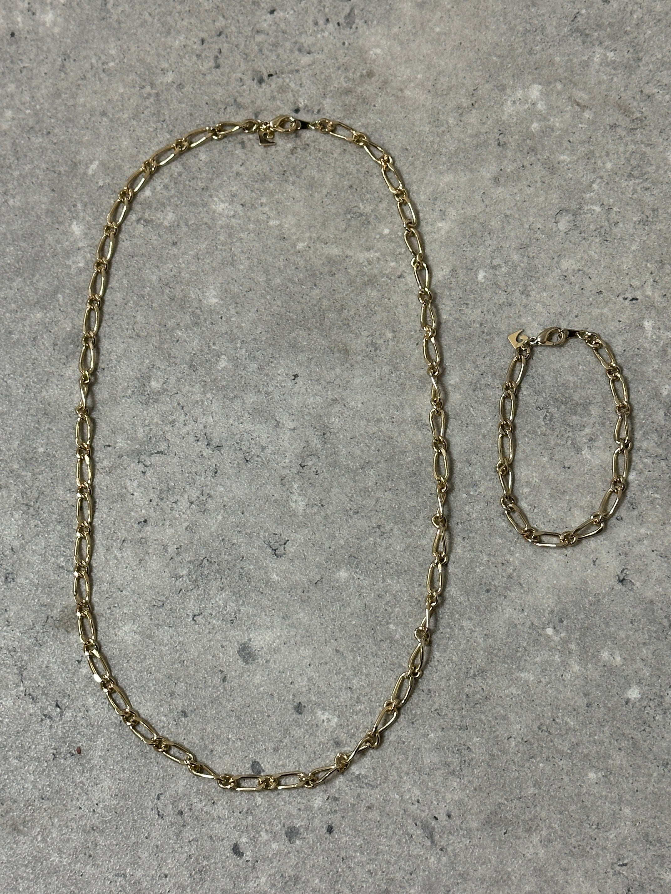 Pierre Cardin gold-plated necklace and bracelet chain set with elegant links and shining finish, displayed on a neutral background.