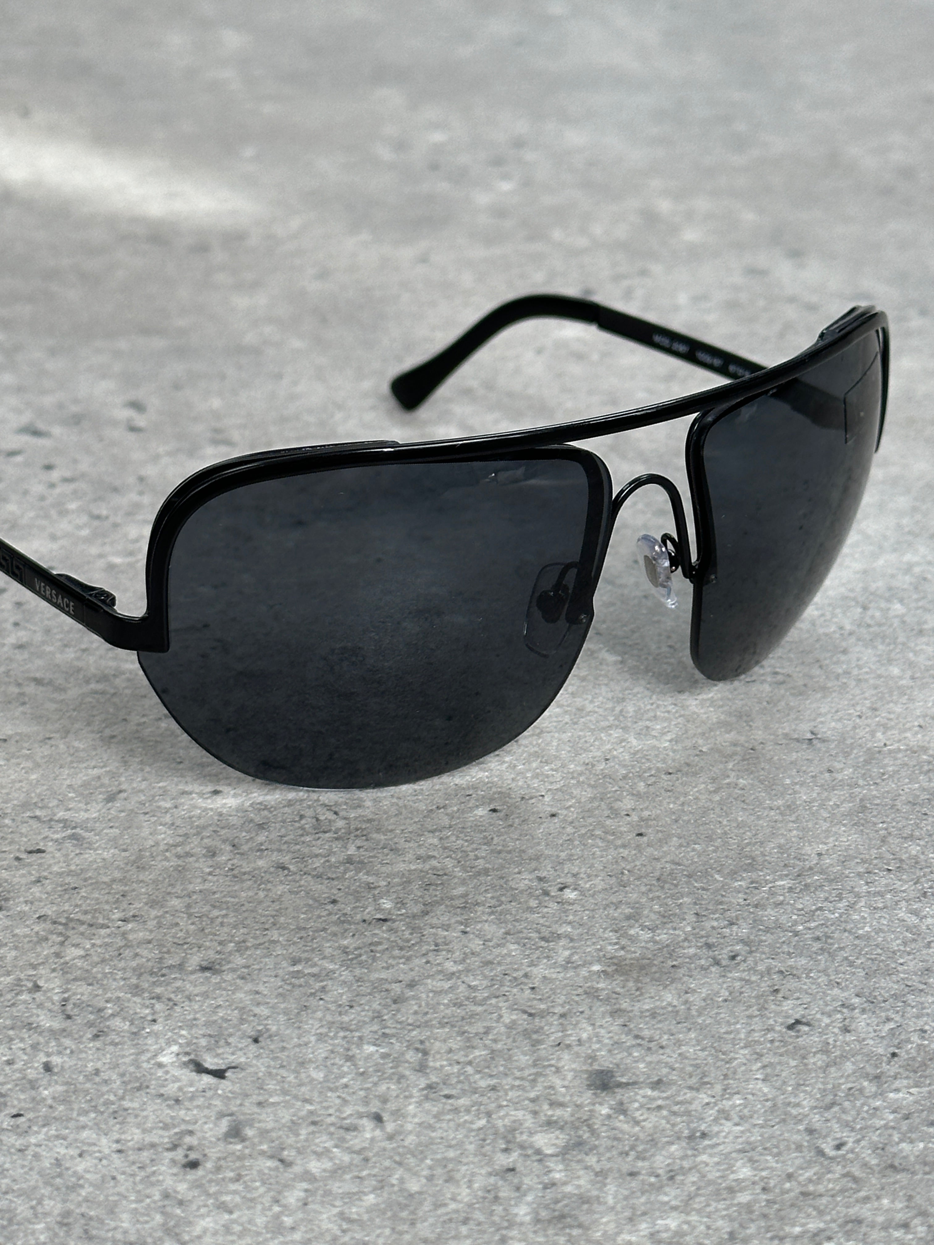 Versace 2000s shield aviator logo sunglasses with dark lenses and bold frames, showcasing iconic Versace branding.