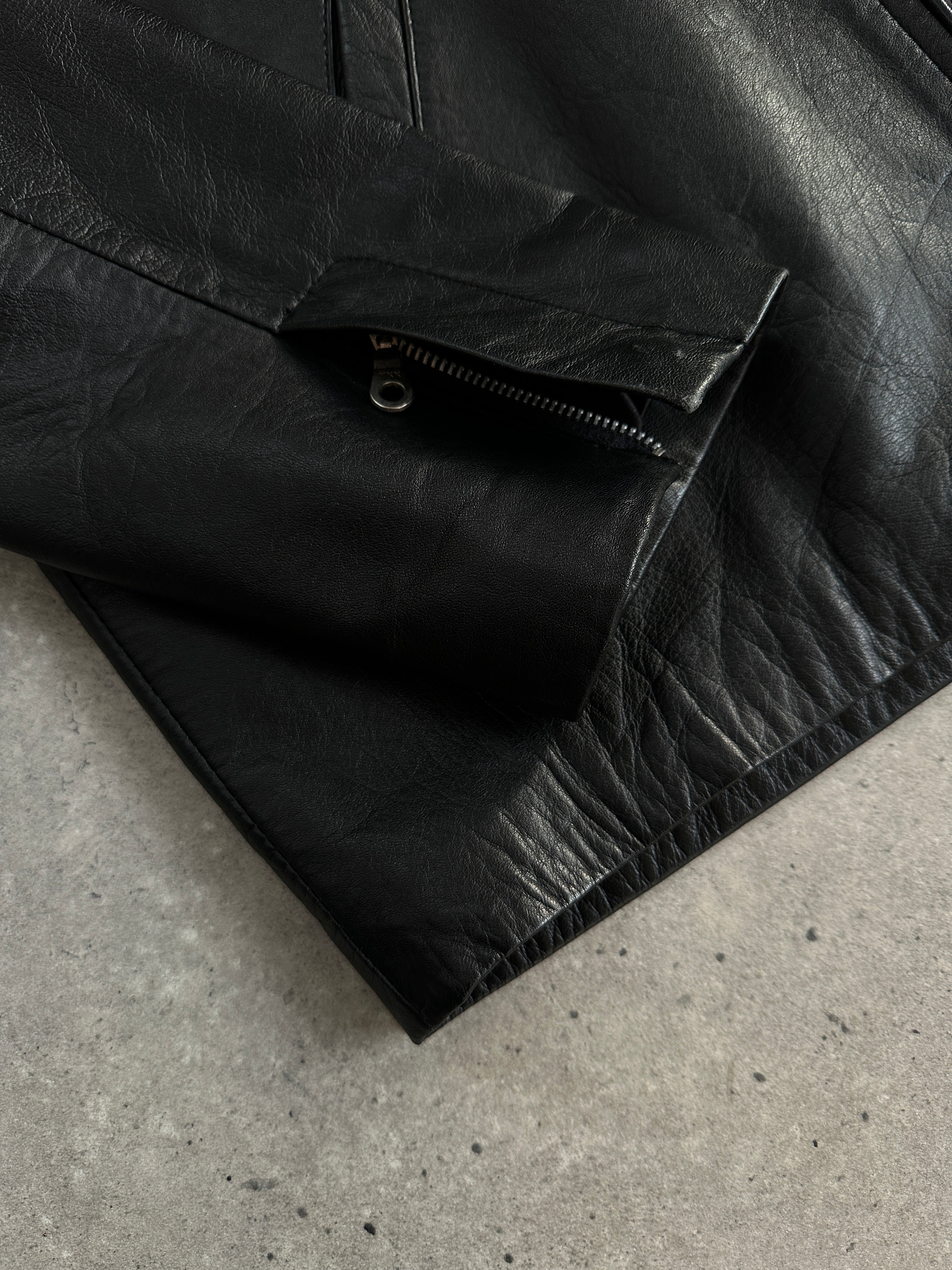 Vintage 2000s minimalist high neck leather jacket in black, shown on a hanger with visible collar and sleek design.
