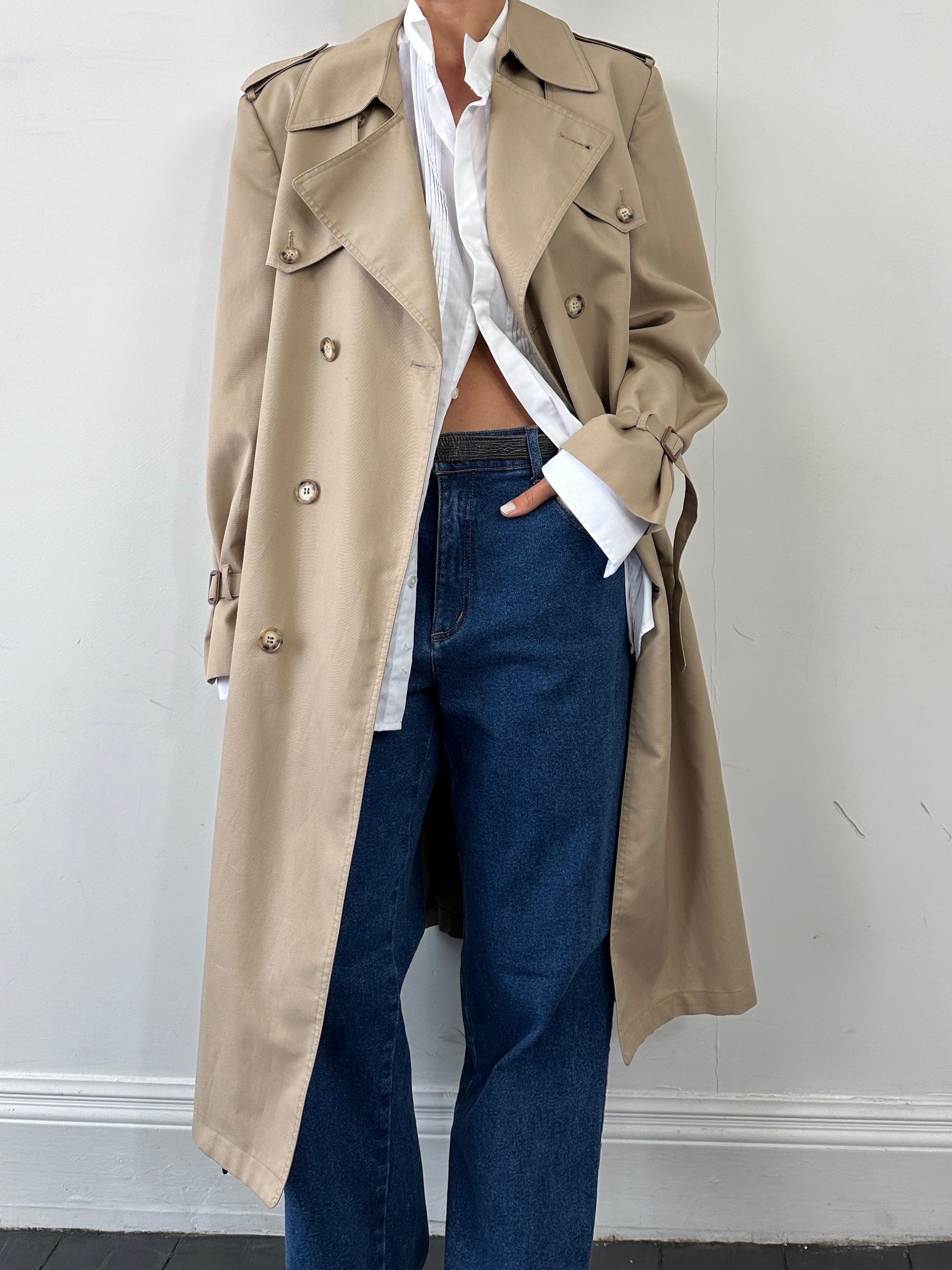 Christian Dior Monsieur double-breasted belted trench coat in size L/XL, shown hanging with classic beige fabric and button details.