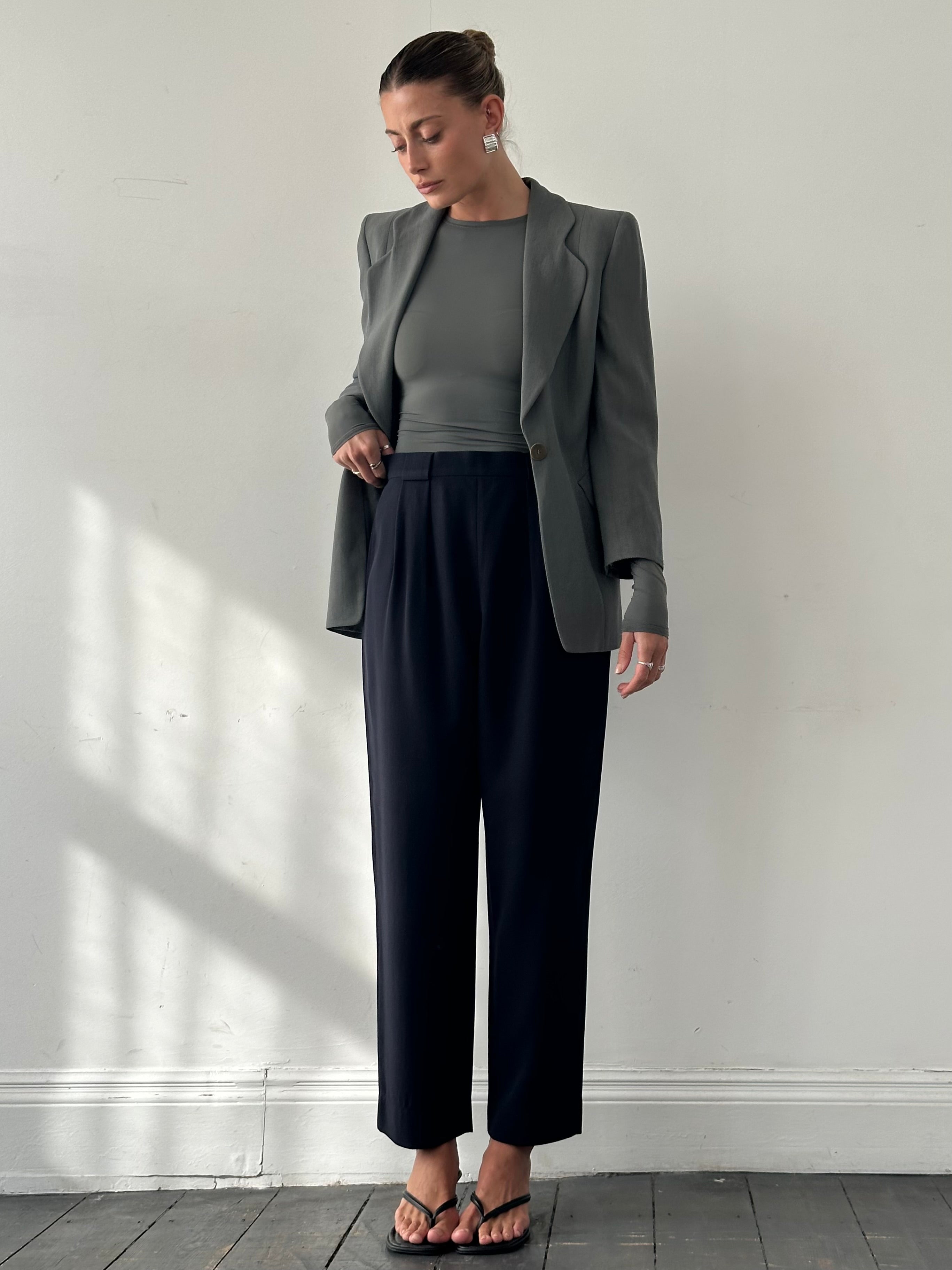 Giorgio Armani 1990s high-waisted tapered wool trousers in dark color, featuring a classic tailored fit and subtle waistband details.