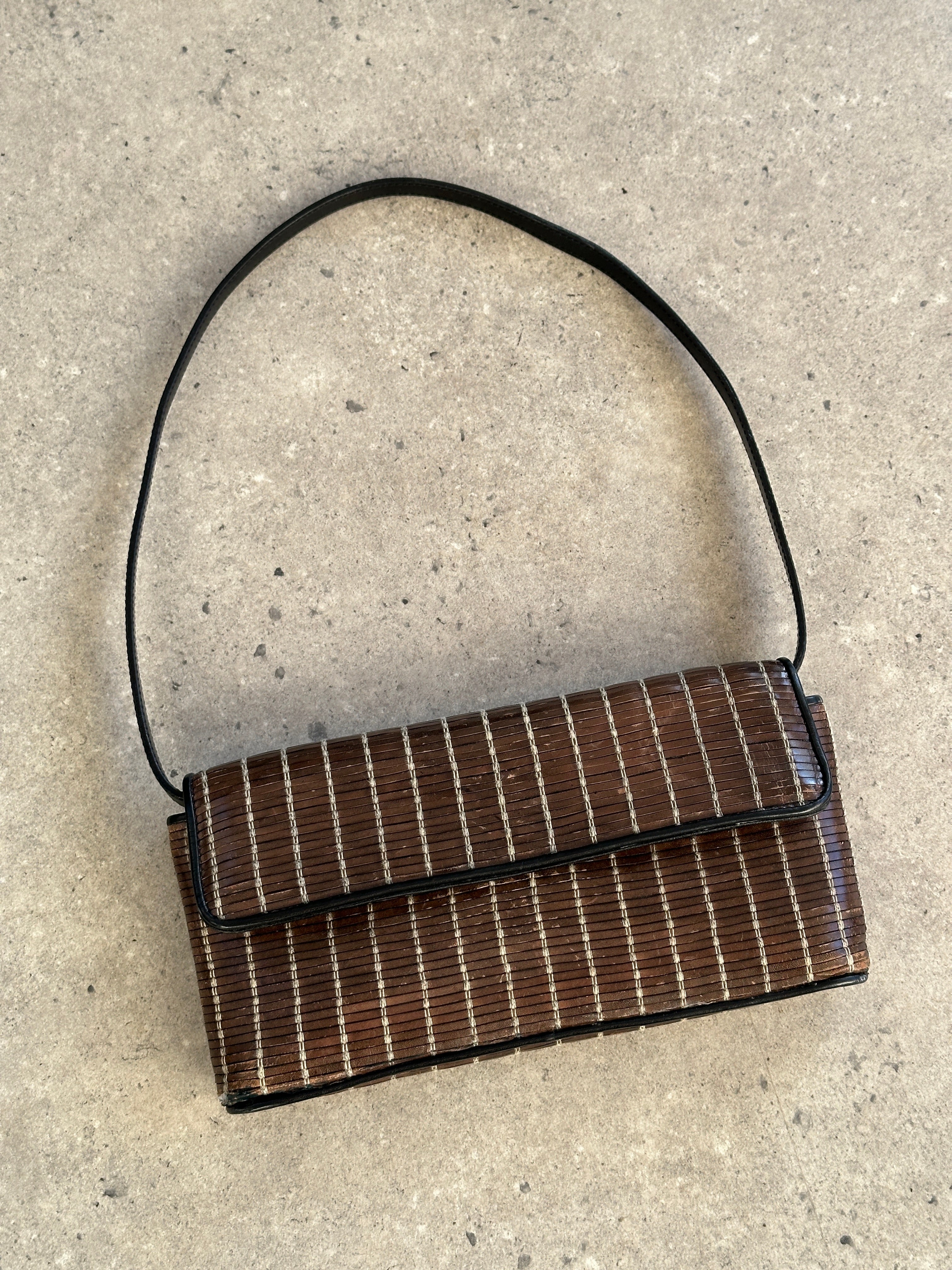 Giorgio Armani leather handbag with sleek design, featuring top handles and subtle branding, on a neutral background.