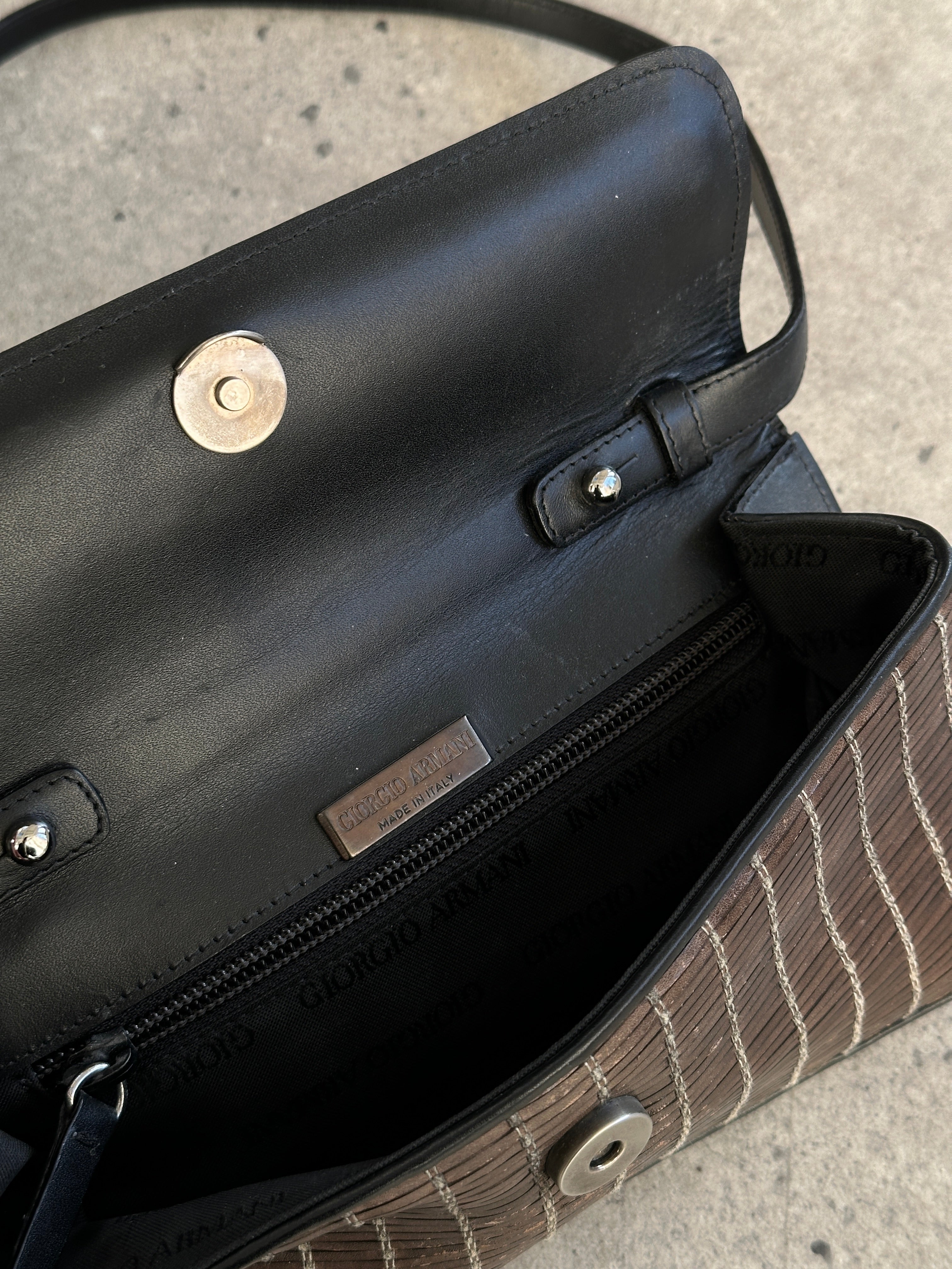 Giorgio Armani leather handbag with sleek design, featuring top handles and subtle branding, perfect for elegant everyday use.