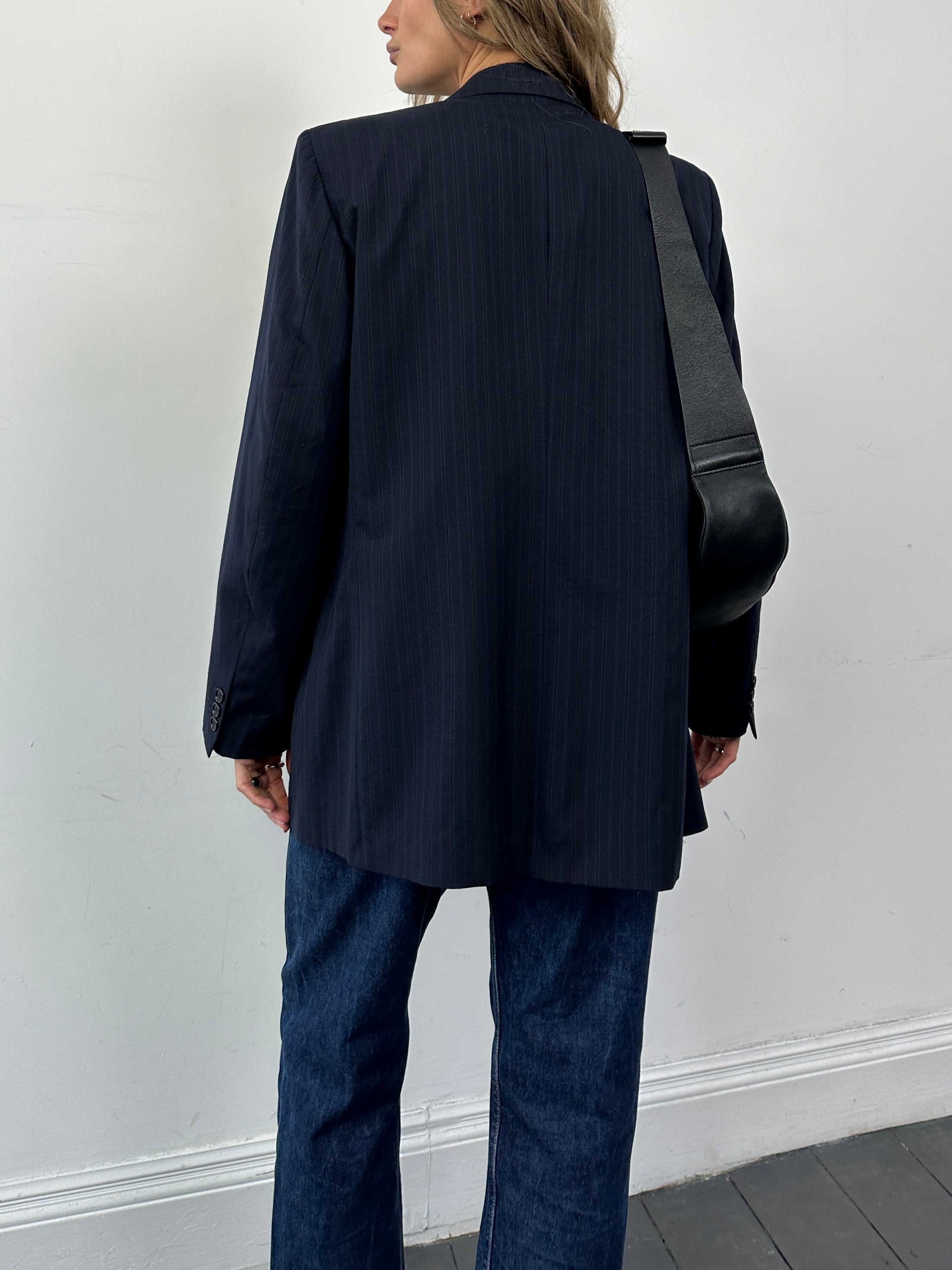 Hugo Boss pinstripe pure wool double-breasted blazer in size L, tailored fit, showcasing lapels and front buttons.