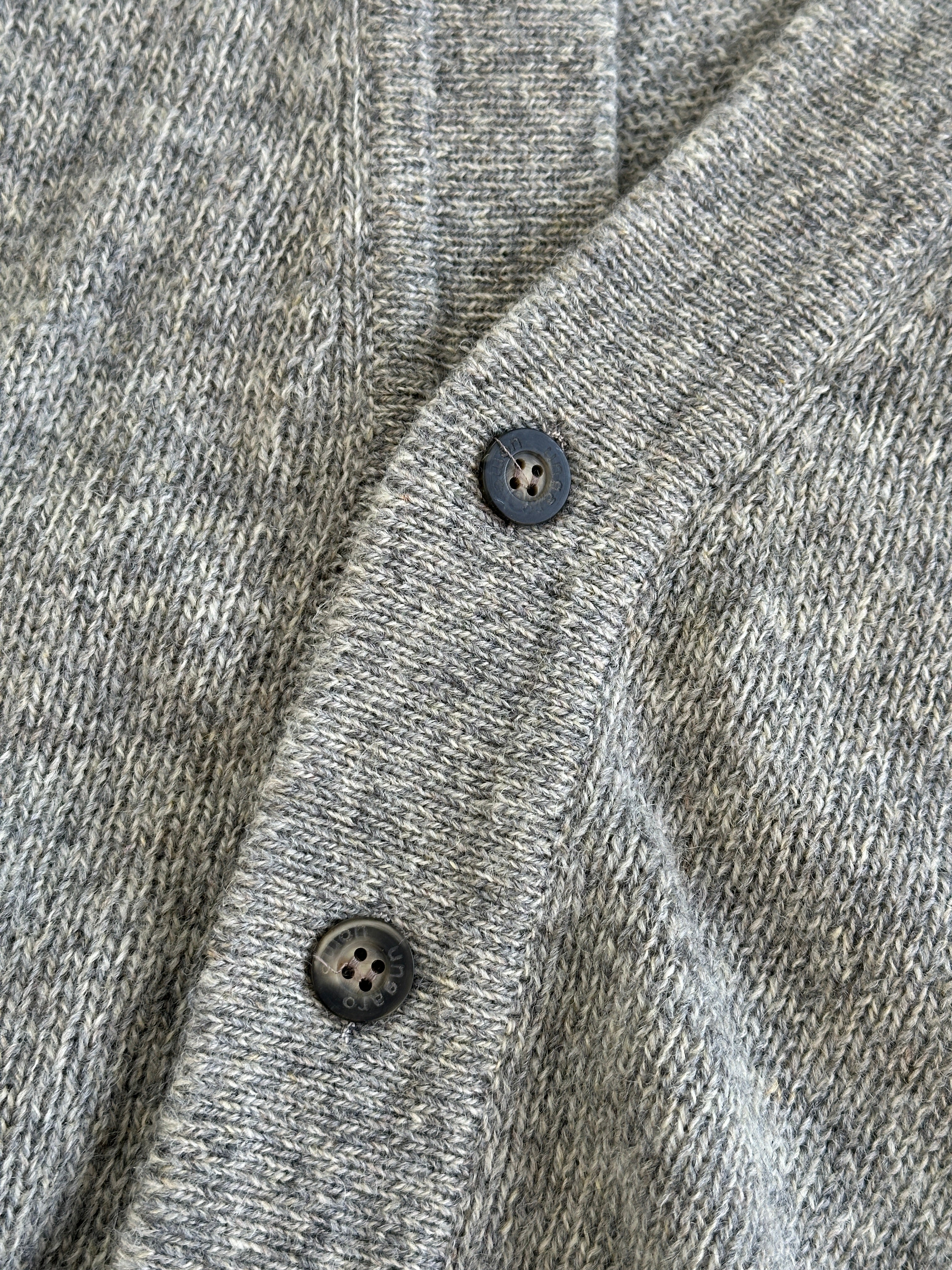 Emanuel Ungaro XL pure wool knitted cardigan displayed on a hanger, showcasing its textured fabric and classic design.