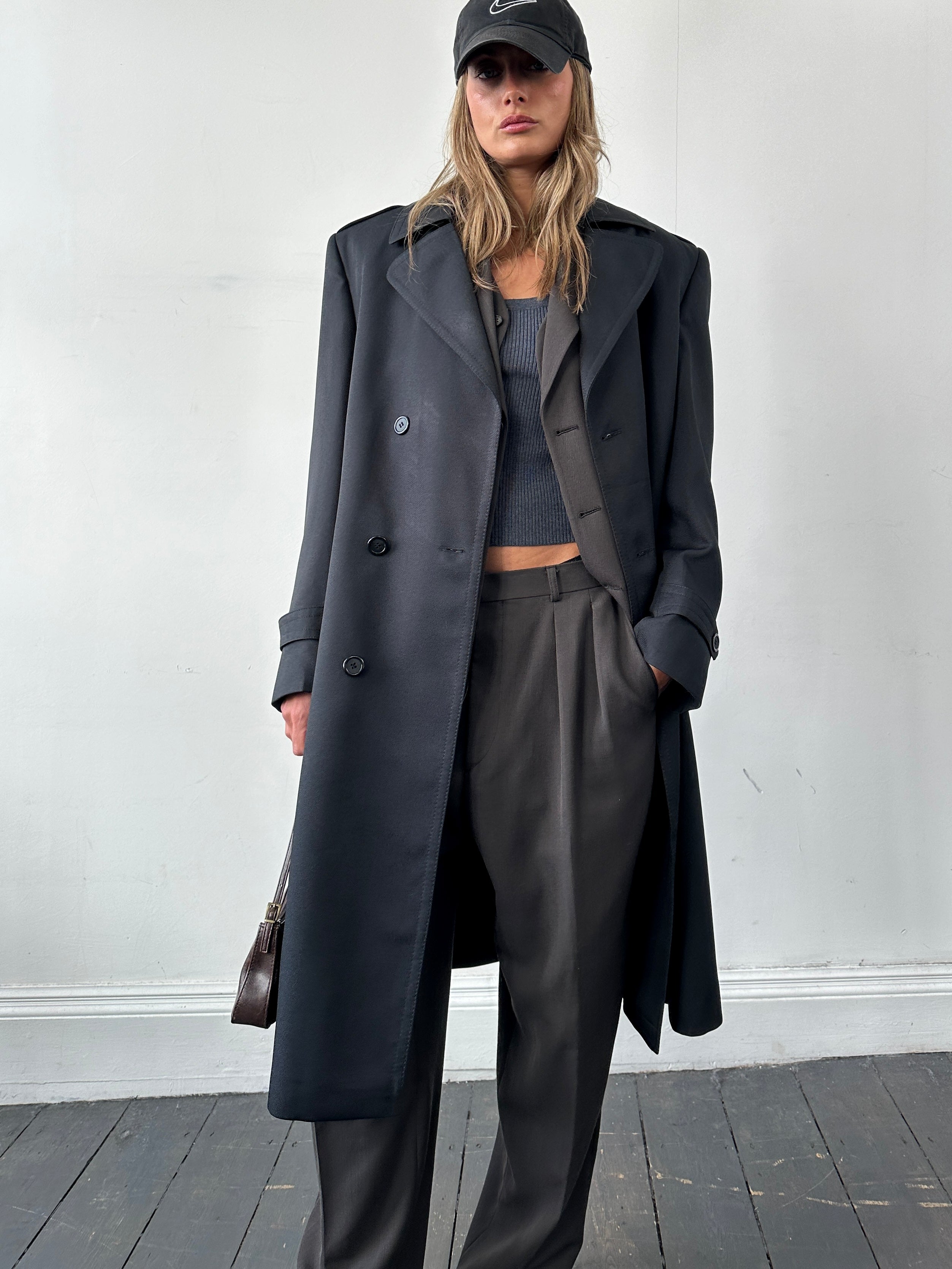 Vintage double-breasted belted trench coat in size L, featuring classic design and tailored fit, shown on a hanger.