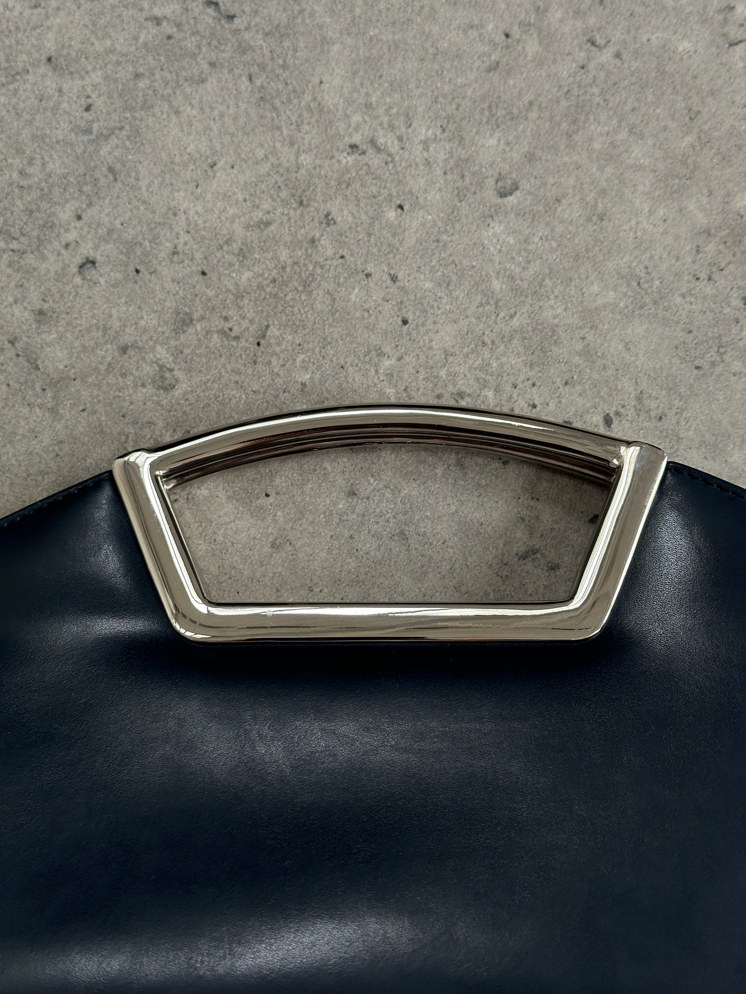 Vintage leather chrome crossbody clutch bag with sleek design and adjustable strap, ideal for stylish everyday use.