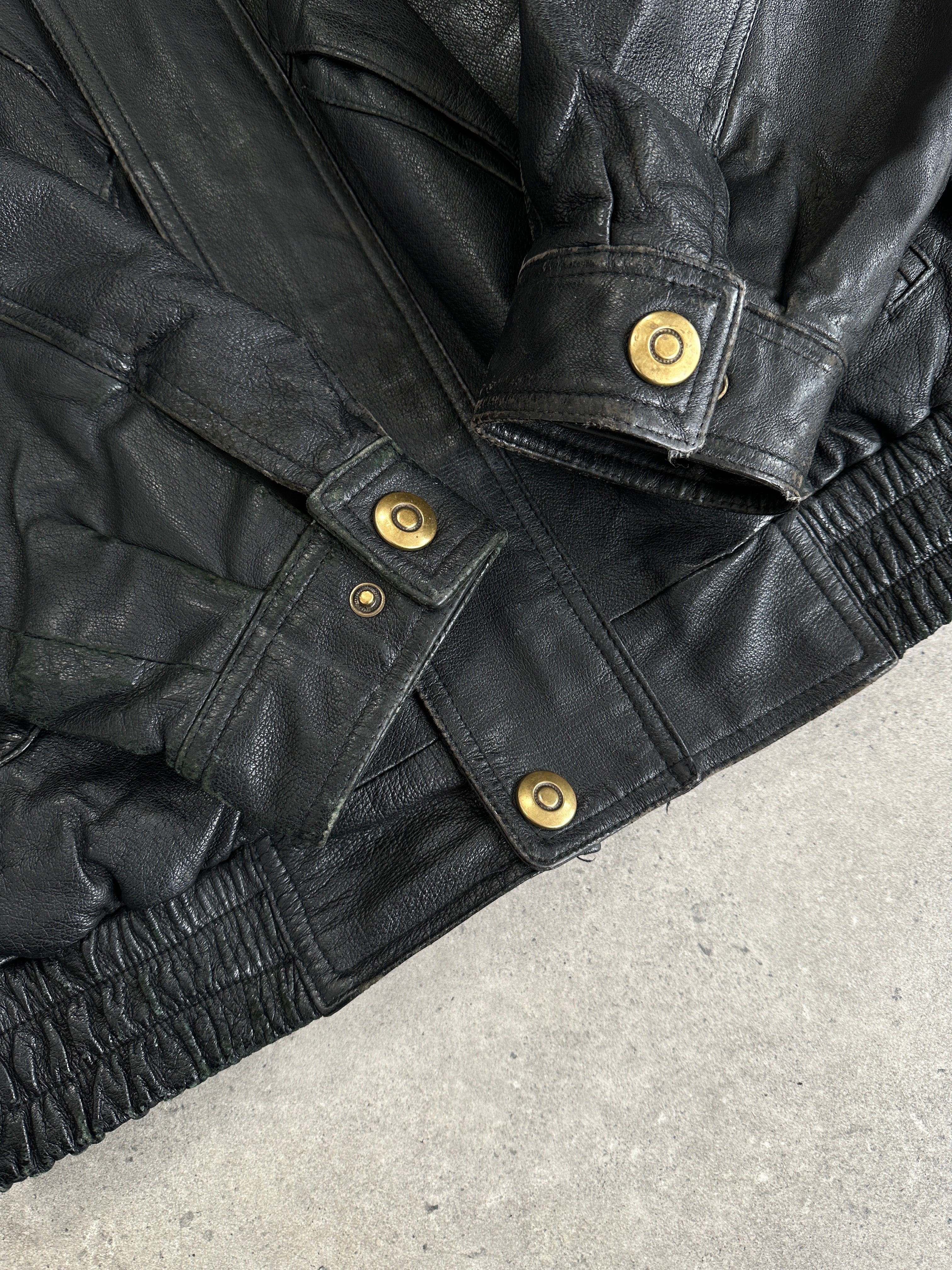 Vintage leather bomber jacket in size L/XL, featuring classic design, ribbed cuffs, and a rugged, vintage style.