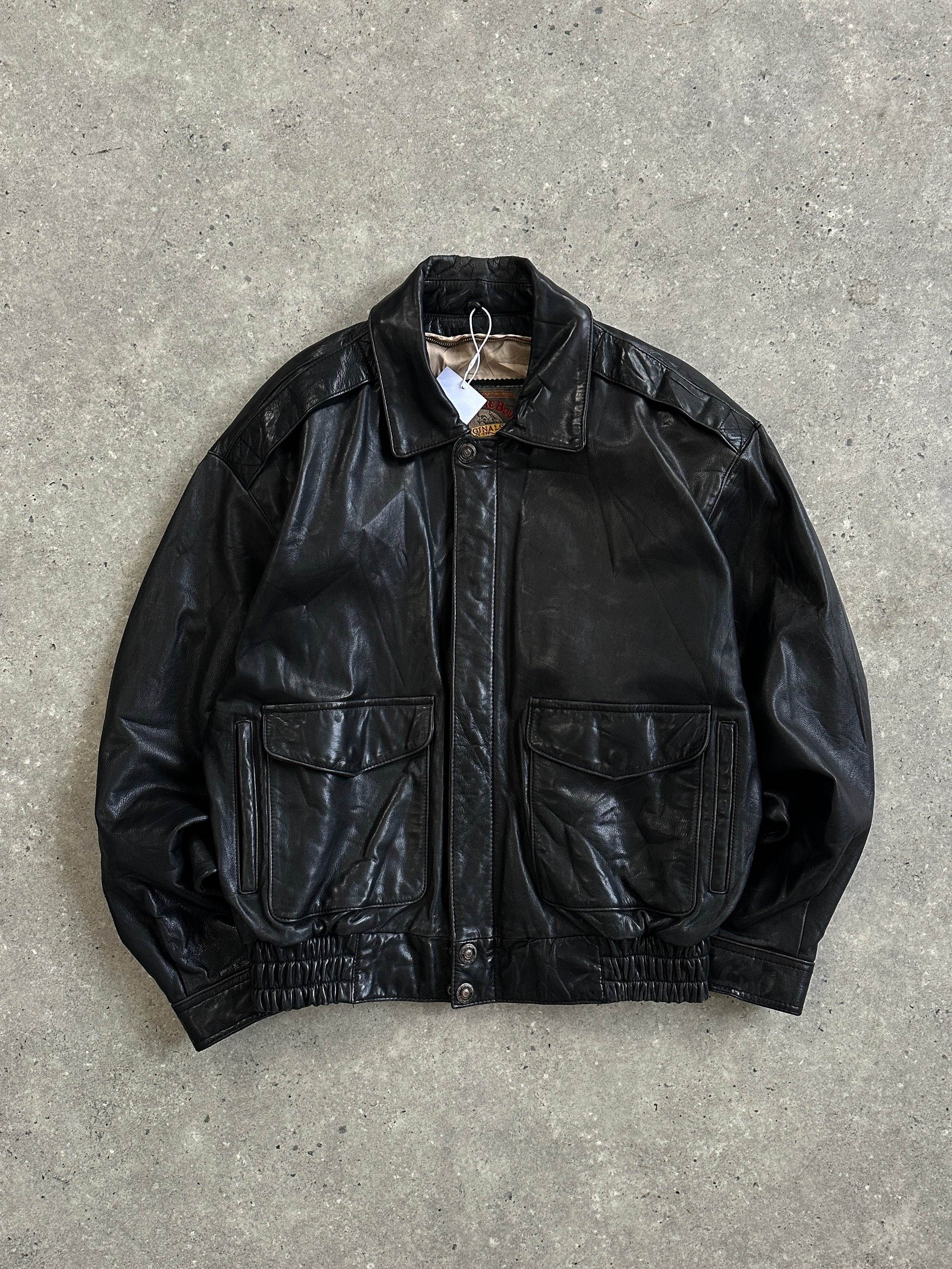 Vintage leather bomber jacket in size S/M, featuring classic design and durable leather material, displayed on a hanger.