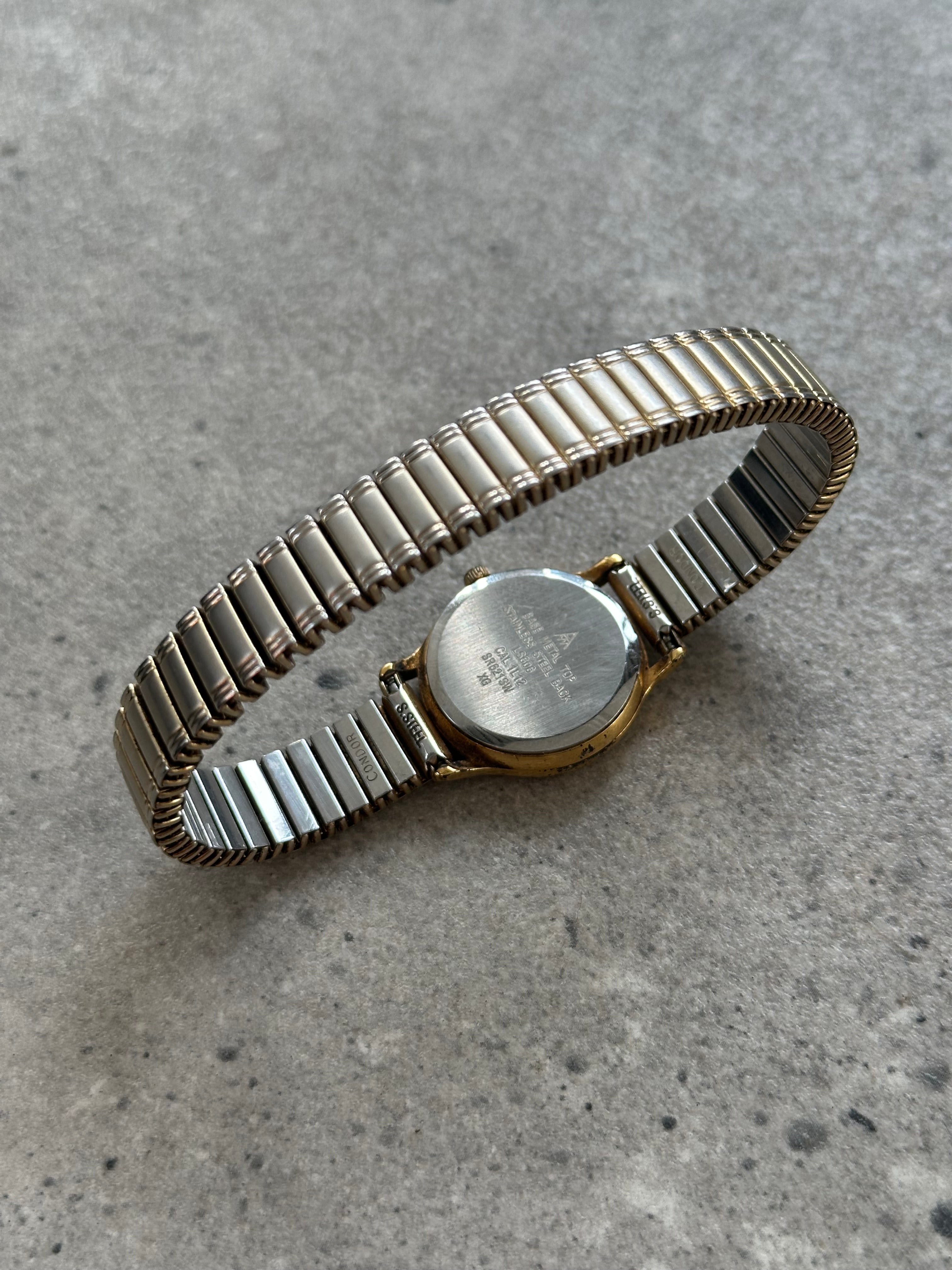 Accurist 1990s gold-tone quartz watch with round dial and metal bracelet, showcasing vintage-style timepiece.