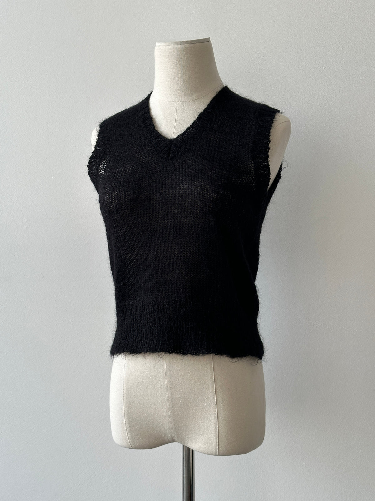 Vintage 1990s mohair v-neck top in soft beige, featuring a classic fit and textured fabric, displayed on a hanger.