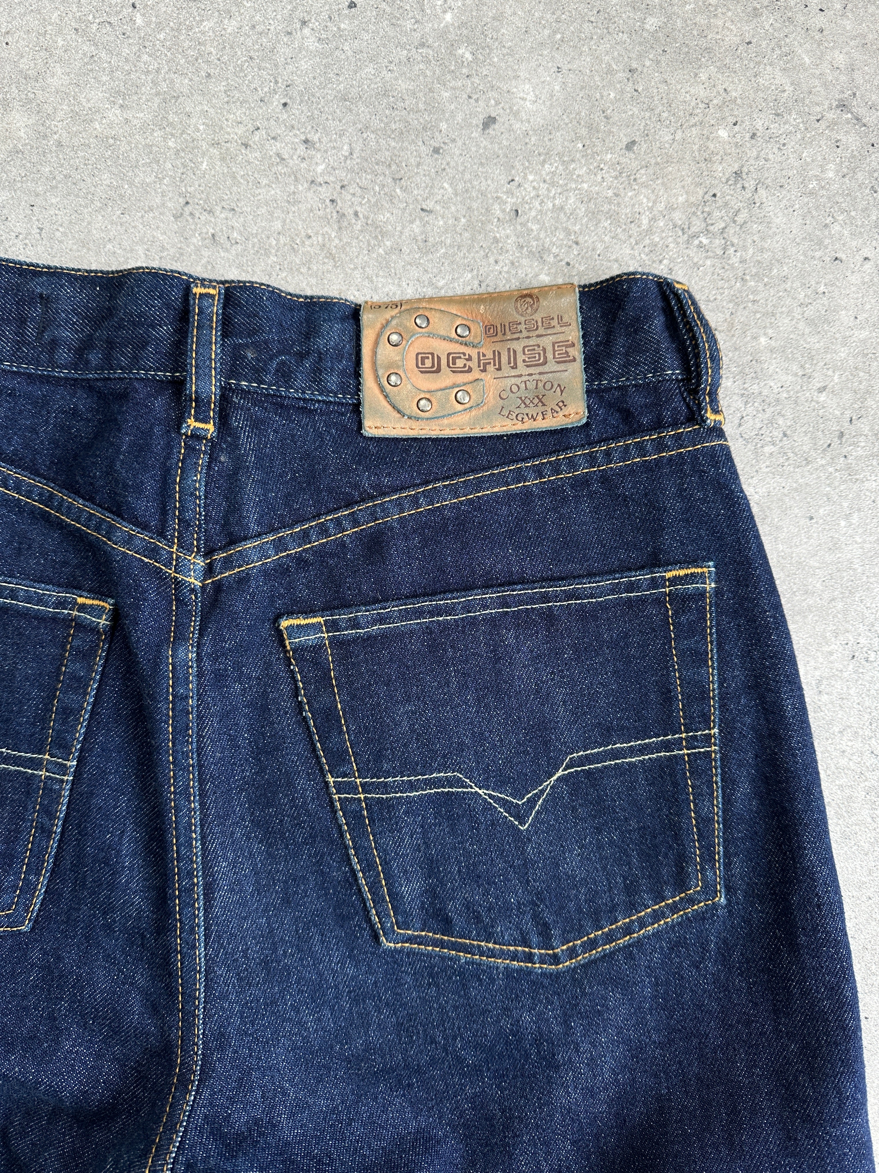 Diesel 575 Cochise 90s straight leg denim jeans in W28 laid flat, showcasing classic blue wash and five-pocket design.