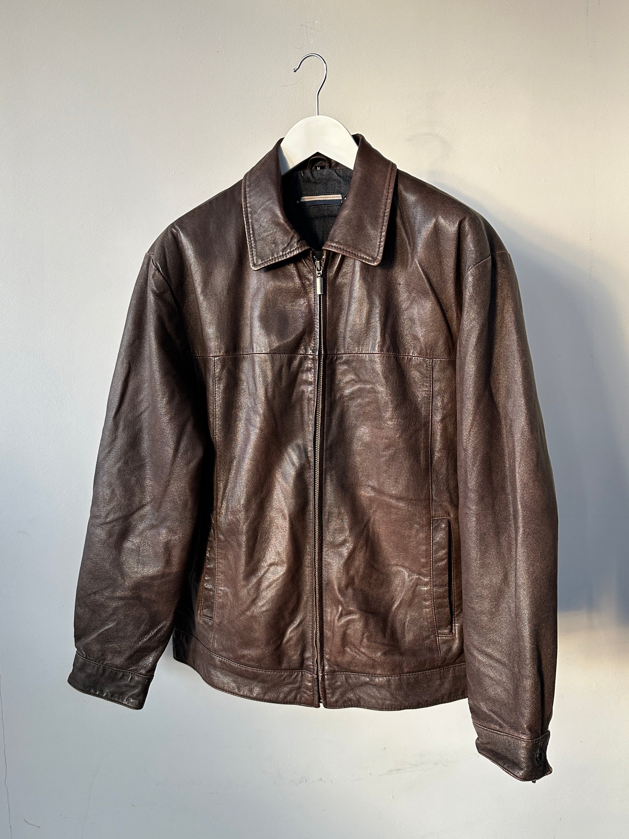 Vintage distressed leather jacket in size M/L with rugged style, featuring worn leather and classic design details.