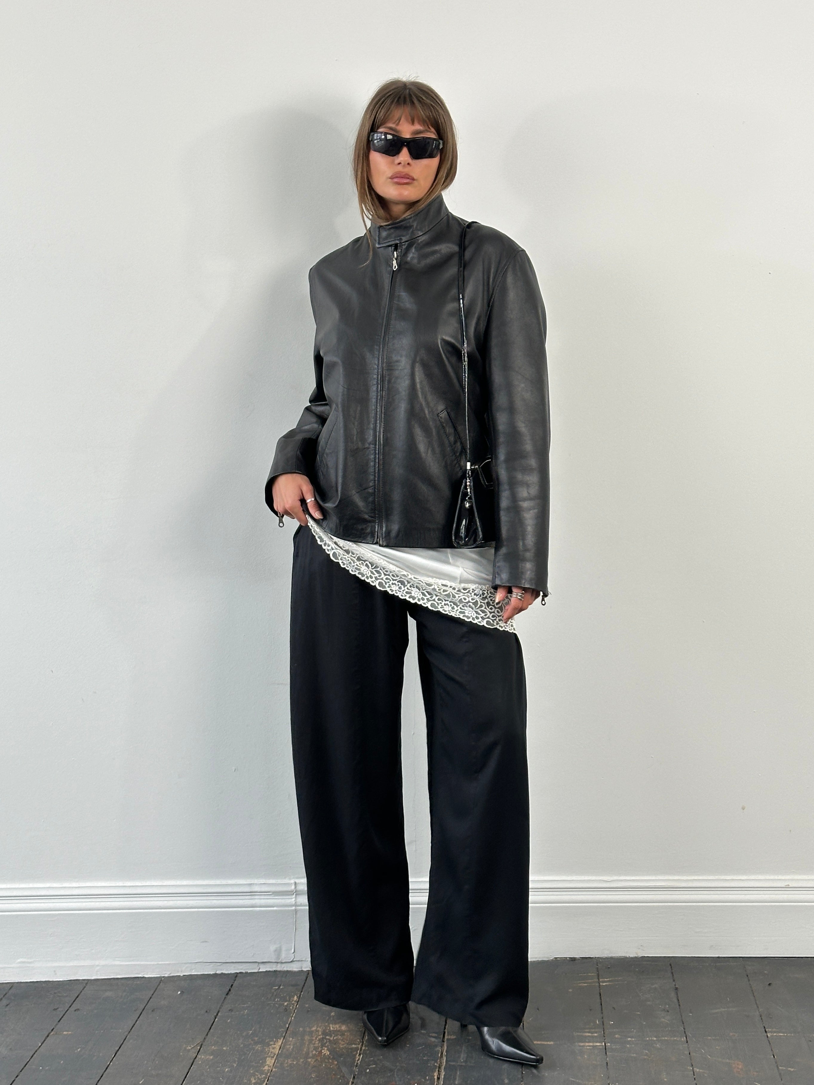 Vintage 2000s high neck leather jacket in black with minimal design, size M/L, featuring sleek leather material and classic style.