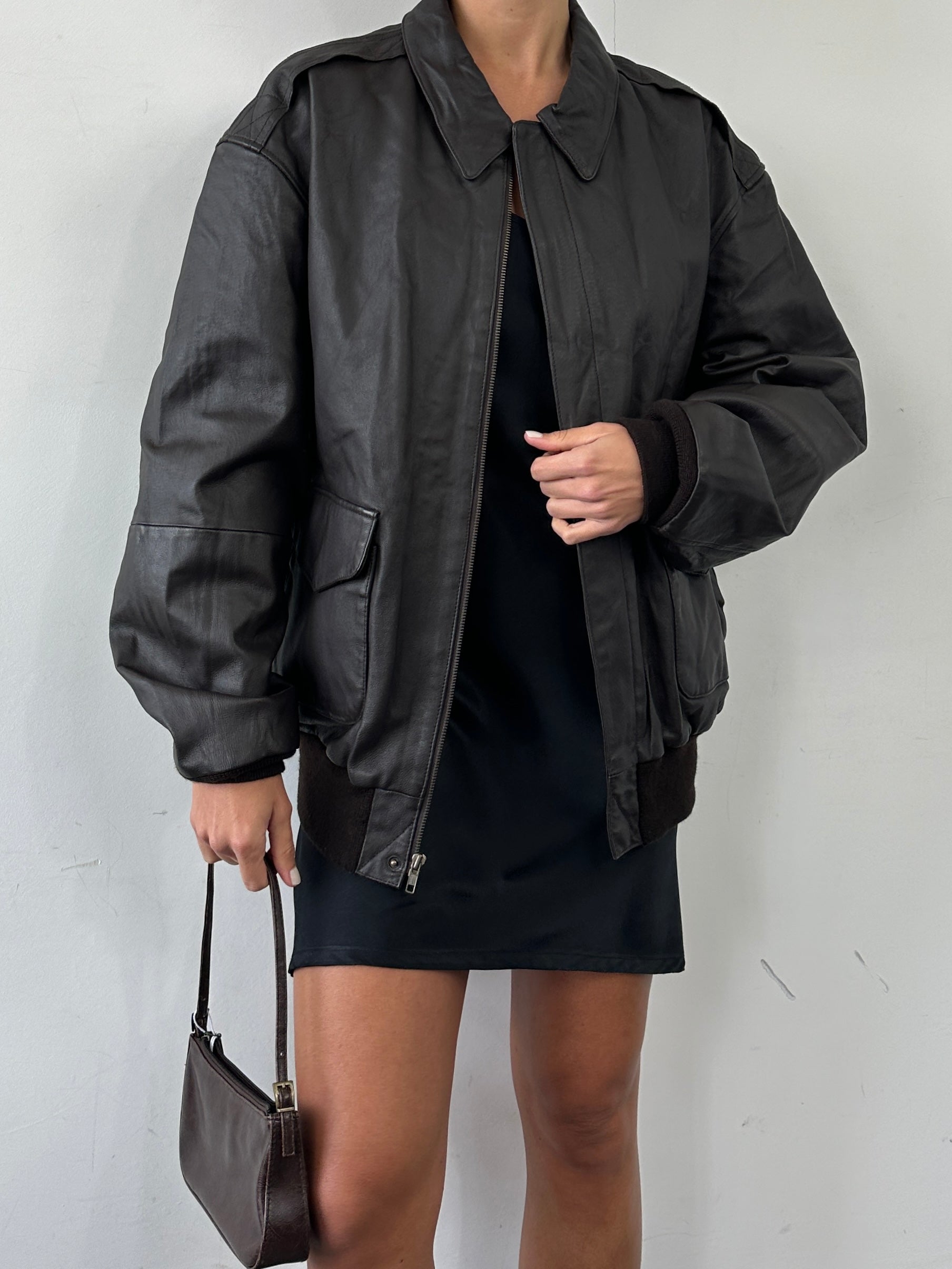 Vintage leather bomber jacket in XL size, featuring classic design, smooth leather, and ribbed cuffs and collar.