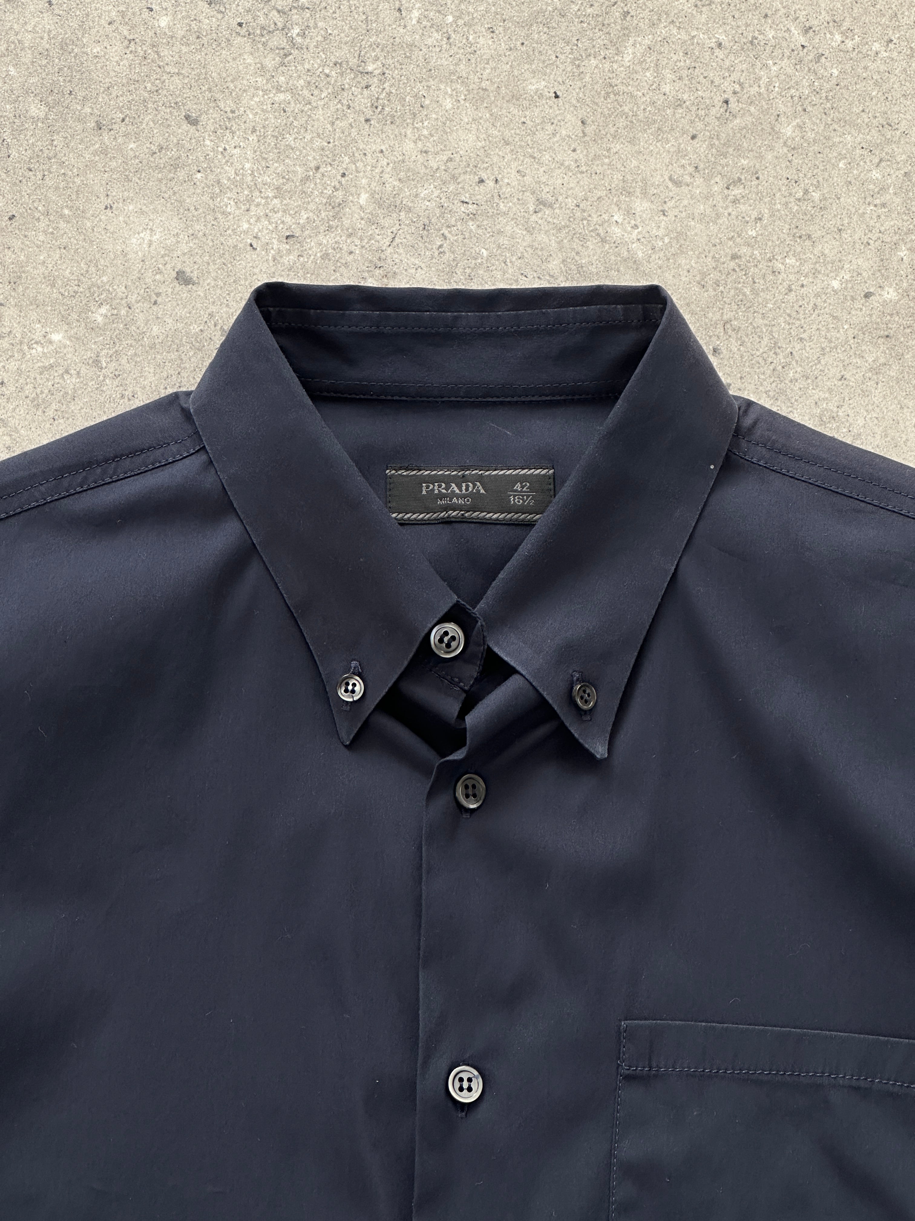 Prada 2000s cotton logo shirt in size M, featuring classic design and Prada branding on the front, displayed on a hanger.