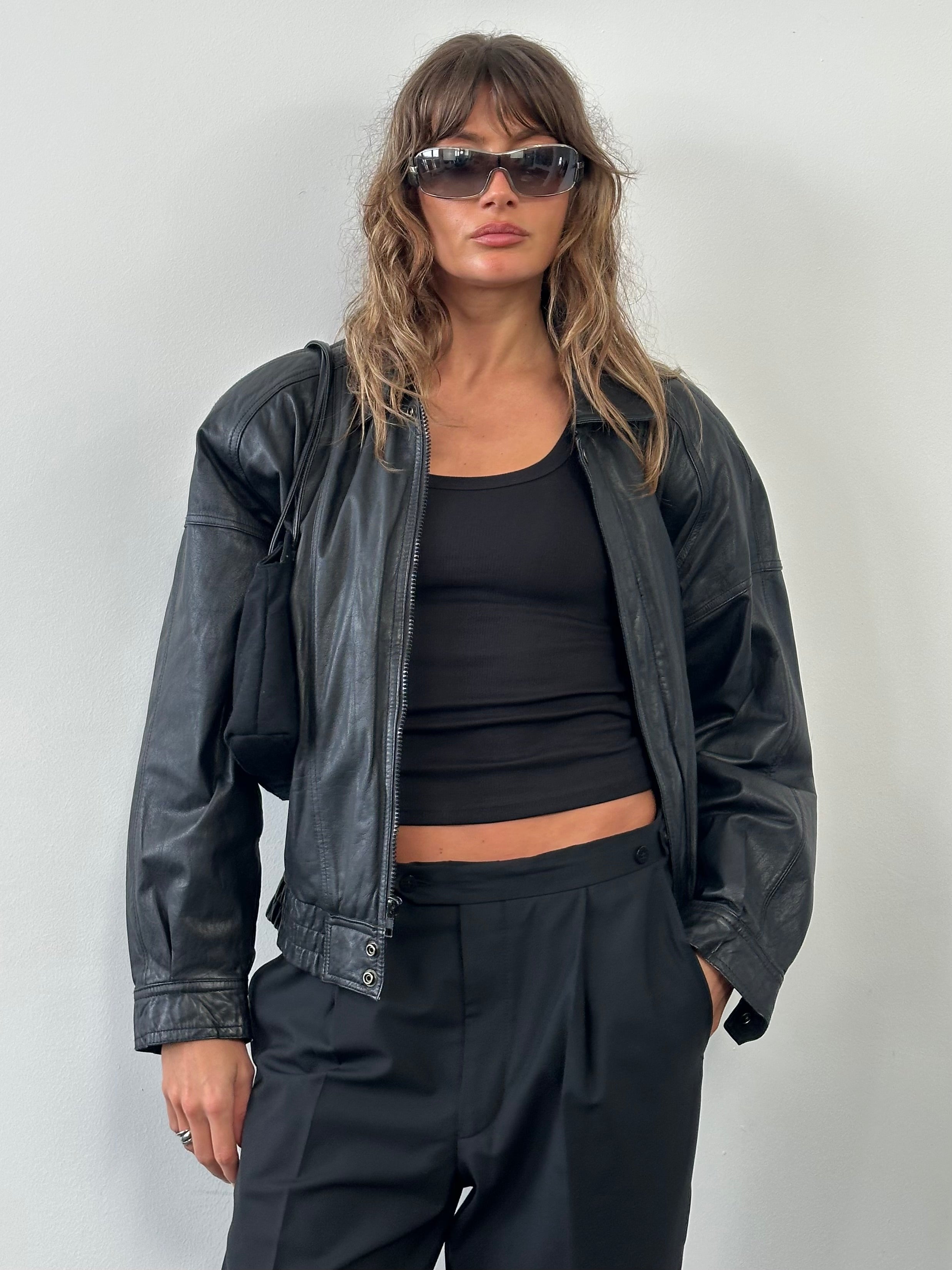 Vintage 1990s leather bomber jacket in size M, featuring classic design with ribbed cuffs and collar, made by Vintage brand.