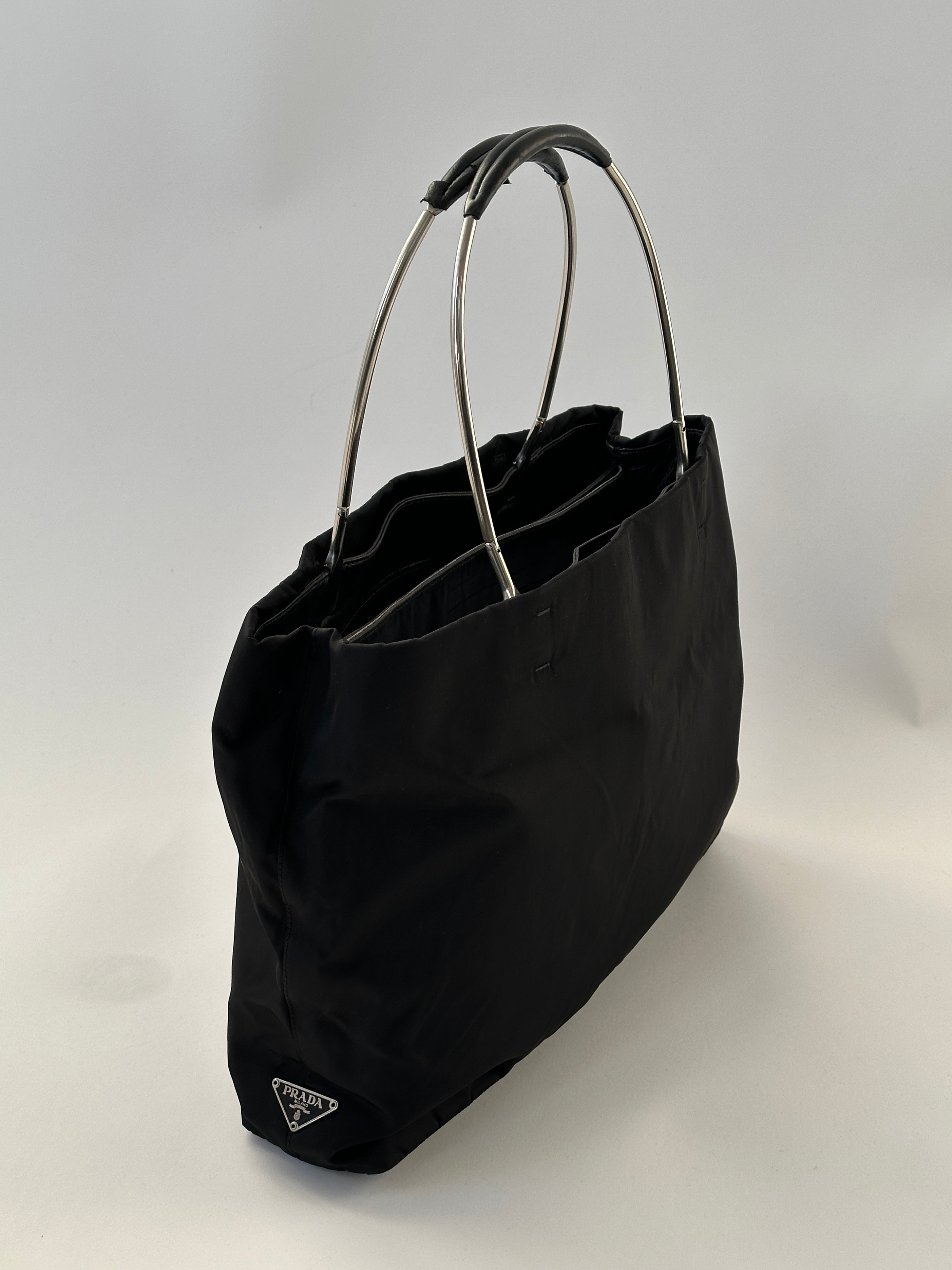 Prada nylon leather tote bag with sleek design, sturdy handles, and spacious interior for everyday use.