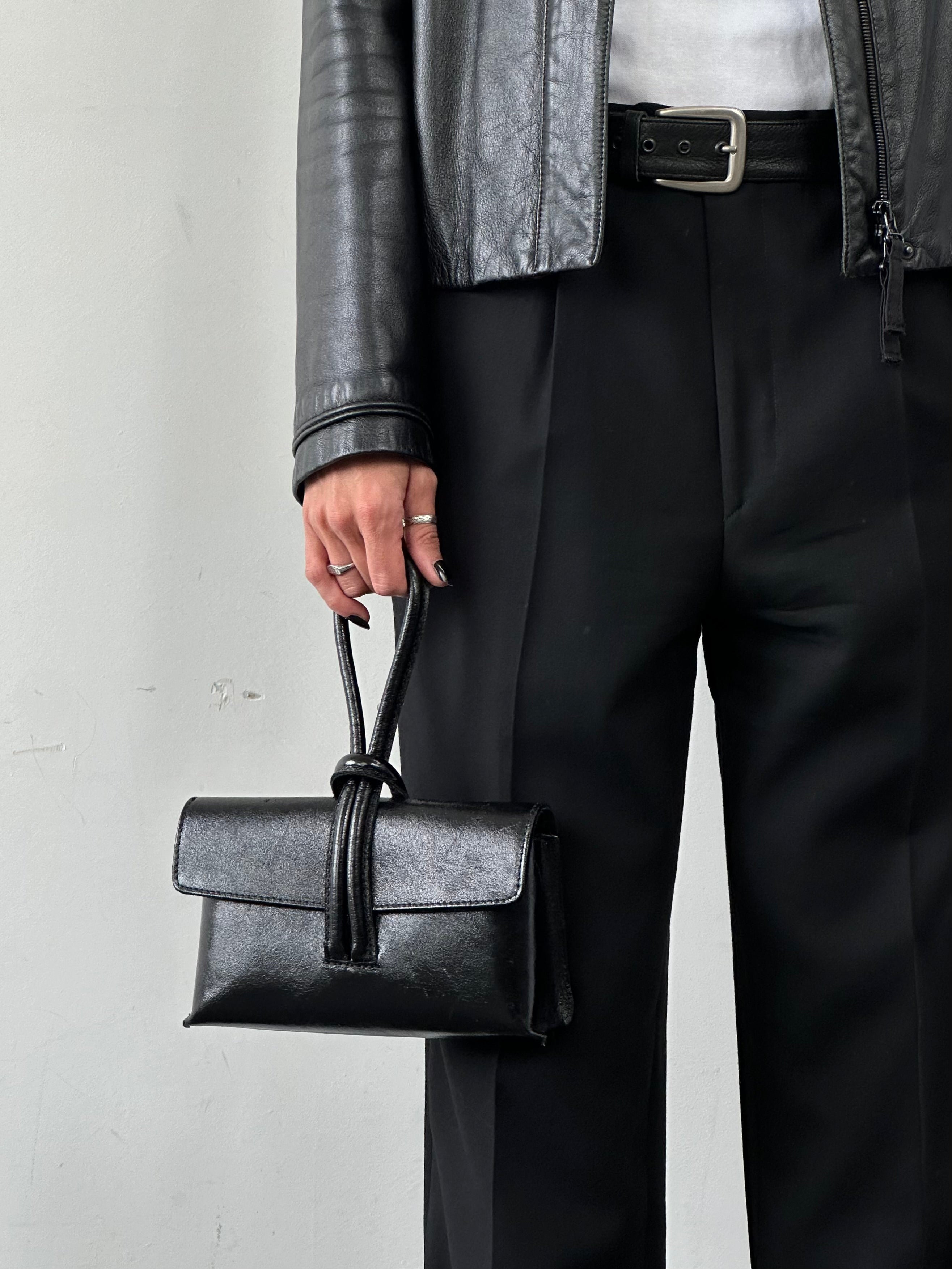 Italian vintage leather crossbody clutch bag with classic design and adjustable strap, featuring a rustic, timeless leather finish.