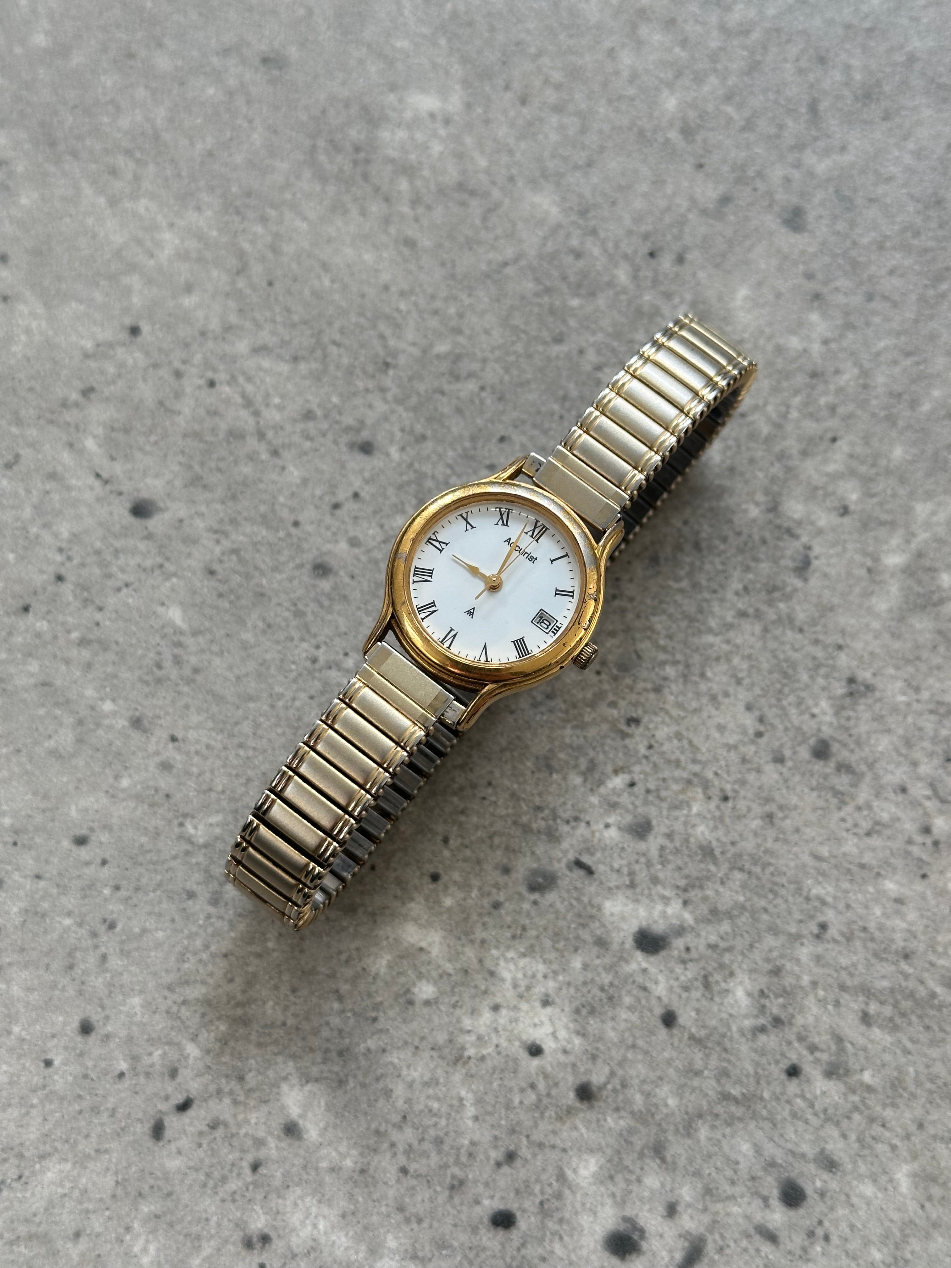 Accurist 1990s gold tone quartz watch with round dial and metal bracelet, vintage style wristwatch.