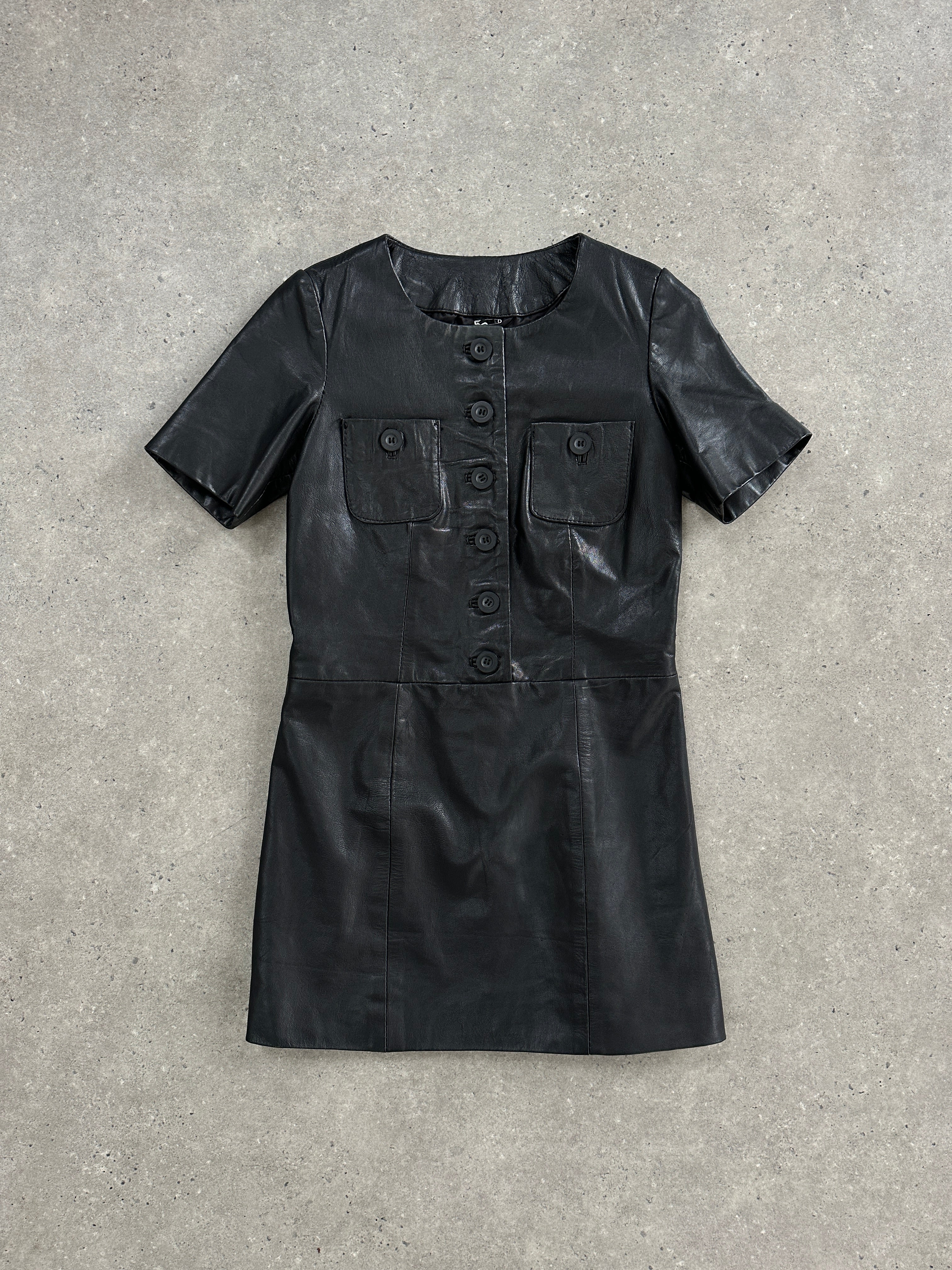 Vintage leather mini dress in size S, featuring a sleek, fitted silhouette and classic retro style, displayed on a hanger.
